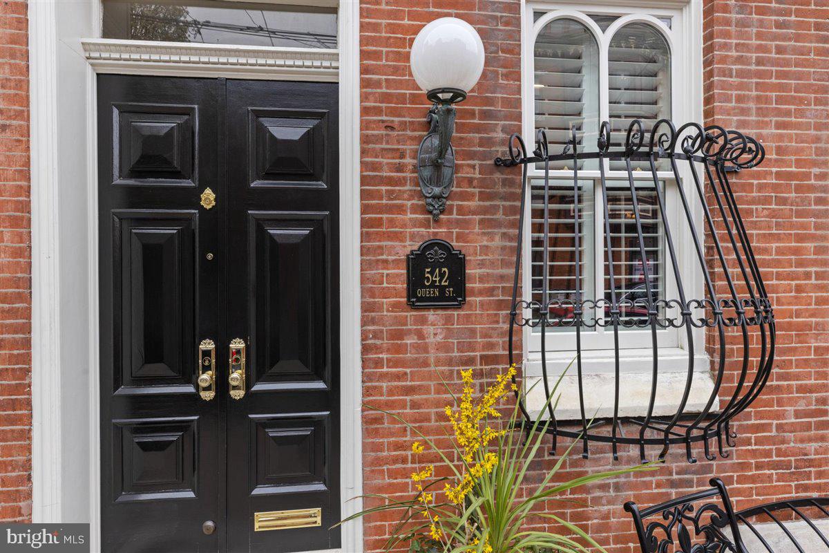 The crown jewel of Queen Village is well known by all for its unparalleled grandeur and towering cathedral windows. The prestige of this home begins with its beautiful brick façade with black wrought iron adornments and a double thick facia that resembles a crown that soars above neighboring homes. This grand home of over 5,000 square feet pulls out all the stops. Immediately upon entering, there is a formal reception room with rich wood paneled wainscotting, a hidden wet bar, and a gas-burning fireplace that creates an intimate gathering place for guests. On the first floor, you will also find an office/library featuring wood columns at the threshold, a beautiful staircase with antique finials and a custom-made stair runner from Belgium with brass hardware, a full marble bath with a walk-in shower, a laundry room with folding area, wet sink, and cabinetry, an oversized coat closet, followed by a back hallway with bonus/guest space and the 2 car garage, and an elevator. After ascending the stately staircase, you will encounter a charming, European-style atrium flooded with sunlight from the three skylights that can take you through French glass doors to the dining room or kitchen. The enormous, south-facing chef's kitchen with three oversized windows, wood floors, gleaming white/glass cabinets, stunning marble countertops that remind you of artic ice with tinges of blue, new commercial appliances (Viking, Subzero) walk-in pantry. When entering the formal dining room, you'll notice the majestic lead crystal chandelier, marble mantle, and wood burning fireplace. Around the corner, you will see a beautifully appointed powder room with crown molding. Completing the second floor is a grand living room that boasts a 14' high ceiling with stunning crown moldings, another wood-burning fireplace with a hand-carved Carrera marble mantle, a floor-to-ceiling built-in curio cabinet, and the beginning of those famous cathedral windows, newly crafted out of solid mahogany and approved by the Historical Society.
Up the turned staircase, you will pass a stained-glass window arrive at the newly finished primary suite. Double doors that are seven and a half feet tall and open to a primary suite with floor-to-ceiling cathedral windows, fourteen-foot ceilings with crown molding, and wood floors. This ensuite encompasses an enormous walk-in closet with wood shelving. The spa-like bathroom boasts a crystal chandelier, a hand-crafted copper soaking tub, a heated Toto toilet, a large walk-in marble shower with marble tiled wainscotting, and a double sink vanity. After leaving the primary suite, you will pass through double French doors into the remaining third floor containing two bedrooms and another new marble bath with an oversized walk-in shower and heated Toto toilet.
This home boasts four new, top of the line HVAC systems, a new 50-year rubber roof, two separate walk-in basements with tons of storage room, and an ELEVATOR that travels from the basement to the rooftop and GARAGE parking for 2 cars. This home is truly special and will delight even the most discerning buyer.
Please note that we just had the interior of the home painted a soft white palette.  It's spectacular.