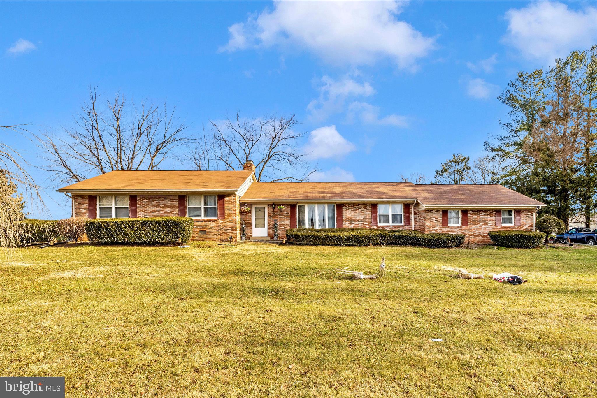 Set against sweeping pastoral views of Montgomery County’s agricultural reserve, this brick rancher offers privacy, space, and peaceful surroundings framed by mature maple trees and established landscaping. Inside, the main level features hardwood floors in the living and dining rooms, a spacious kitchen, and a welcoming living area with a wood-burning fireplace and sliding doors leading to a large concrete patio ideal for entertaining. The home includes three main-level bedrooms, including a primary suite with a walk-in closet and private bath, plus a second full bathroom. The finished lower level offers a large recreation room with a second fireplace, a full bathroom, and two separate den spaces with closets. A side-load 1.5-car garage with an automatic opener and parking for 10+ vehicles adds exceptional convenience for everyday living and entertaining. Make this exceptional property yours before it’s gone.