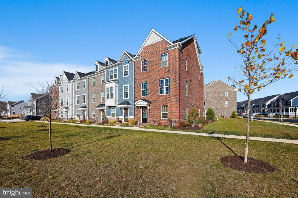 Welcome to 439 Holloway Street, a stunning end-unit townhouse, offering the perfect blend of style, space, and convenience. This Ryan Homes Strauss model, the largest in their Composer Series, boasts a fourth level and a beautiful brick front elevation with a fully bricked side. As you enter the lower level, you'll find a versatile office space, a half bath, an oversized storage closet, and a rear entry two-car garage equipped with two EV charger outlets. The main level features luxury vinyl plank flooring throughout, a bright and spacious open-concept kitchen, dining, and living area with a gorgeous upgraded ceiling fan, and a second half bath perfect for entertaining. The kitchen is a chef's dream with a large island, built-in hutch/coffee bar, stainless steel appliances, and quartz countertops. Upgrades include matte gold cabinet hardware, a goose neck faucet, herringbone tile backsplash and upgraded refrigerator. Glass doors lead to an oversized deck with low-maintenance composite decking, perfect for morning coffee or dining al fresco. The bedroom level offers a luxurious primary suite with carpet, a large walk-in closet, a beautiful upgraded ceiling fan, and an ensuite bathroom featuring a dual sink vanity, an upgraded tile package, soaking tub, and a separate stand-up shower with gorgeous tile surround. This level includes two additional carpeted bedrooms, and a hall bath with a tub shower combo. The laundry room, including a convenient laundry tub, is also perfectly situated on the bedroom level. The fourth level presents a carpeted bedroom with a lovely upgraded ceiling fan, a full bathroom with a step in shower and a rooftop deck, providing a second outdoor retreat, the perfect spot to relax. Conveniently located near top-rated schools, Dandee Creek Marina, and state parks, this exceptional townhouse is ready to be your new home. Don’t miss out—schedule your tour today!
