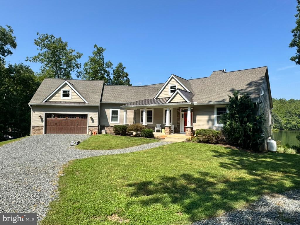 Nestled in the serene enclave of Cuckoo's Nest, this exquisite raised ranch home offers a luxurious lifestyle with unparalleled access to the stunning Lake Anna. Upon entering, the "infinity-like" lake views will delight and beckon you   Built in 2015, this meticulously maintained residence boasts five spacious bedrooms and three and a half bathrooms, providing ample space for relaxation and entertainment. Step inside to discover an inviting open floor plan that seamlessly blends comfort and sophistication. The heart of the home features a gourmet kitchen equipped with stainless steel appliances, including a double oven and built-in range, complemented by upgraded countertops and a generous pantry. The adjoining dining area and living space, adorned with hardwood floors and recessed lighting, create an ideal setting for gatherings. A cozy gas fireplace with a stone mantel adds warmth and charm, perfect for cozy evenings. Retreat to the primary suite, where luxury meets tranquility. Enjoy the spa-like experience of a soaking tub and a walk-in shower in the primary bath, along with a spacious walk-in closet. Additional bedrooms are thoughtfully designed, ensuring privacy and comfort for all. The exterior of this property is equally impressive, featuring a private beach for outdoor and water enthusiasts. With approximately 272 feet of waterfrontage, indulge in activities such as fishing, swimming, and boating right from your backyard. The property includes a private boathouse on deep water featuring two slips, equipped with an electric hoist, and two floating jet ski docks, making it easy to launch your watercraft. The screened-in porch will invite you to enjoy the lake in shaded comfort. Be sure to take in the birds-eye lake views from the upper level of the boathouse. The lush, wooded lot spans nearly an acre, providing a peaceful retreat with stunning views of the lake and surrounding nature. Additional highlights include a two-car attached garage, ample driveway parking, and a security system for peace of mind. The outdoor space is perfect for entertaining, featuring a BBQ grill and exterior lighting to enhance your gatherings under the stars. Located near the water's edge, this home offers a unique blend of luxury and leisure, making it an ideal sanctuary for those seeking an exclusive lifestyle. Experience the beauty of lakeside living in this exceptional property, where every detail has been thoughtfully curated for your comfort and enjoyment.
