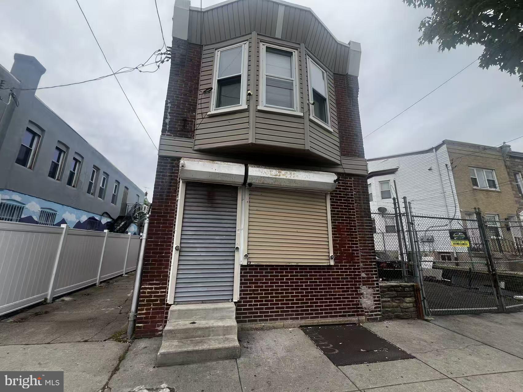 Single‑family home on 10,000 sq ft lot. Storefront on ground floor; 2‑bedroom 1‑bath apartment upstairs. Left side driveway for 3‑car parking. Attached 1,200 sq ft garage with roll‑up gate; rooftop can be converted to balcony with railings. Adjacent vacant land (5,000 sq ft) on the right  can park up to 10 cars.