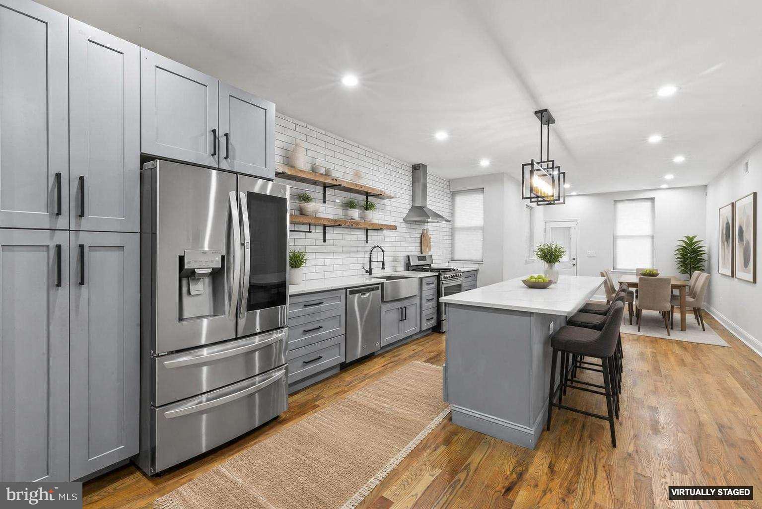 No gimmicks here: qualified buyers may be eligible for 100% financing, no PMI, and a $5,000 lender credit toward closing costs through a special financing program. Pair those savings with six years remaining on a traditional 10-year tax abatement (just $1,856/year), and you'll find exceptional long-term value in this fully renovated, generously scaled 4-bedroom home featuring abundant living space and a large private outdoor area.   High-efficiency HVAC, leased solar panels with a low monthly cost (system maintained and insured), and thoughtful updates throughout provide comfort and predictability in expenses. Hardwood flooring, high ceilings, and natural light define the interior, creating an open and inviting feel from top to bottom. The main level flows easily from a spacious living room—well suited for large-scale seating and everyday gathering—into a classic dining area at the rear of the home that connects seamlessly to the kitchen.  The kitchen serves as the true command center of this home, anchored by a large island that functions equally well for prep, dining, and gathering. Long quartz countertops with seating for four extend the usability of the space, while full-height white tile provides a clean architectural backdrop. Warm reclaimed wood shelving, soft gray cabinetry, and simple black hardware balance the design with texture and warmth, complemented by a stainless hood and gas range that bring a grounded, functional cooking presence.  Upstairs, the bedrooms are notably large with excellent closet space throughout. The primary suite stands out with a walk-in closet and a spa-like bathroom that elevates the entire home, featuring a tall glass-enclosed shower with dual rain-maker heads and separate wand sprayers, along with beautifully integrated tiled shelving that provides elegant and functional storage.  The fully finished basement offers an unusually large footprint with full ceiling height and strong flexibility of use. Previously set up as a serious dedicated fitness and weight lifting space, it also provides ample storage and multiple closets. The rear utility area includes laundry, sump pump, and radon mitigation system for low-maintenance living, along with a conveniently integrated half bath that adds everyday practicality.  The rear of the home opens into an expansive, fully private outdoor space that is rare in the city, complete with two-car parking and additional room for grilling, gardening, and outdoor lounging. Exceptionally private and filled with natural light throughout the day, it functions as a true extension of the home and has been described by the current owners as an “oasis in the city.” A striking industrial-style automated corrugated steel rear door adds both character and security, while the concrete surface is well maintained and properly pitched for excellent drainage.  The block itself is wide, tree-lined, and marked by a genuine sense of neighborhood connection. What continues to draw people to this area is access to space—Fairmount Park, the reservoir, and surrounding green landscapes are all close by, offering a level of breathing room that’s rare in city living. At the same time, Girard Avenue, Center City, and the Art Museum area remain easily accessible. Strawberry Mansion offers something increasingly uncommon in Philadelphia: scale, space, and a neighborhood identity that remains intact, with broad streets, mature trees, and historic architecture sitting alongside immediate access to major parkland and water views, creating a setting that feels open, grounded, and deeply connected to the city’s natural landscape.