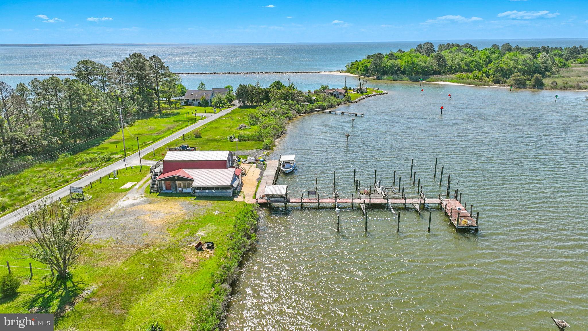 Secluded Oyster House is residentially zoned as non-conforming water-dependent commercial use in a historic fishing village on St. George Island, just off the Potomac River near the Chesapeake Bay.  Perfect for a business that requires water access.  It could serve as a private marina for family and friends who need safe-harbor docking on the Intracoastal—reported 4’ MLW in the channel and at the pier. It could be used for seafood distribution, charter boat fishing, event venues, conservation and environmental programs, education, aquaculture marina, or tour boat docks—purchaser to confirm desired uses. The oyster house and pier have electricity and running water. There are two half bathrooms in the building.
Build your Island dream home on a unique property with centuries of maritime history dating back to the founding of Maryland in 1634. The Oyster House is considered an ancillary use and is independently grandfathered as part of any new single-family residential building permit.  There is an additional sewer hookup for a single-family home.
Historic St. George Island attracts permanent and migratory birds and is renowned for osprey nests, blue herons, and purple martins. Osprey and martins return annually to the nesting sites over Island Creek off this parcel—new roof on the Oyster House in 2021. The Oyster House is on Public Sewer.  This was a massive undertaking and has been completed.