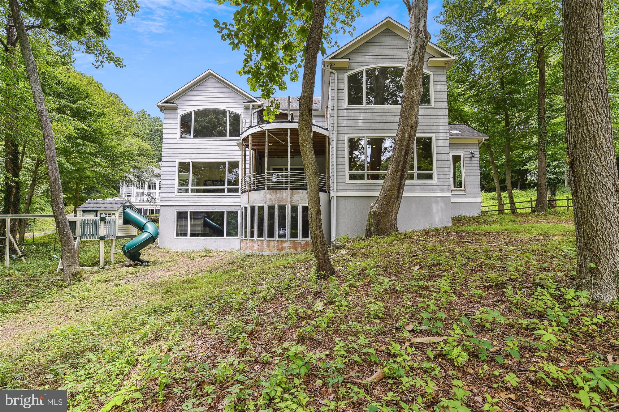 Just a stone's throw away from Historic downtown Annapolis is "Paradise Found."  1.486 acres w/ a spacious custom built home waiting for your finishing touches.  From the time you enter the front door, you can see the water.  There are 3 levels, including a full basement with a waterfront walk out.  All stories have high ceilings & are pre-engineered with Radiant Heat.  There are 2 geo-thermal heatpumps.  The trim work in this home is incredible, designed & built specifically for this site. Note the 9+' arches, custom doors & open floor plan. Some of the wood was milled from this lot.  The rooms are all very large w/ windows galore,  rendering lots of natural light & wonderful views.  The front yard has been prepped for a putting green & has a sprinkler system.  The wrap around porch accesses the home in 2 spots, great for a separate home office entry.  The super sized gourmet kitchen offers a 6 burner gas range, dbl wall ovens, Sub-Zero refrig., new Bosch dishwasher, icemaker & more, w/  gathering places, storage, desk area, granite & Corian counters, flowing into casual dining, formal dining, family room & outside porch, all overlooking the waterfront. The large formal living room also faces the waterfront.  There are 3 garage bays & doors & a playground all set up. Enjoy the fire pit & pull up your kayaks & paddle boards at the water's edge.  Sellers have a current AAC pier permit.   Great location!  Close by boat, car, golf cart, bike, etc to fishing pier, marinas, 2 seafood restaurants, Navy Golf Course, local stores & downtown fun.  Sellers regret leaving before their dream home is complete.   Rear upper porch is in the process of being replaced at Seller's expense.  There is a rough in for a luxurious water view primary bath & a few other unfinished projects.