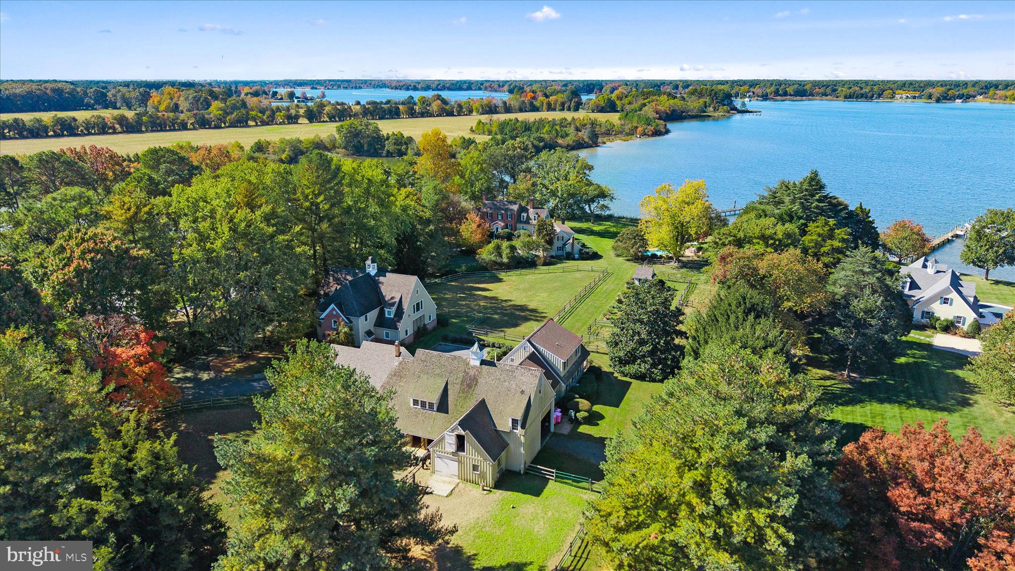 Swan Point is an exquisite waterfront estate set on approximately 4.5 acres, offering sweeping westerly views across the Tred Avon River.  A gated, paved driveway with cobblestone curbs welcomes you to this private retreat.

This stately Colonial features 4 bedrooms, 4 full baths, and 3 half baths, thoughtfully designed for both intimate living and grand entertaining.  The formal living room, complete with a wood-burning fireplace, opens to a charming three-season porch.  A separate formal dining room provides an elegant setting for gatherings.  The gourmet kitchen includes a breakfast area and adjoining den with a wood-burning fireplace and 600-year-old heart pine floors that are radiant-heated.  A spacious sunroom extends from the kitchen and flows seamlessly onto a brick patio with a built-in grill and is just steps from an inground, heated pool with spa and brick surround.  A separate laundry room with powder room, and an attached two-car garage finish off the main level.  The partially finished basement offers additional living space with a wood-burning fireplace, full kitchen, and powder room.

A private staircase leads to the primary suite, located in its own secluded wing, featuring two walk-in cedar closets and a luxurious bath with soaking tub and separate shower.  The main staircase leads to additional bedrooms, including a second primary suite, a third bedroom with hall bath, and a fourth bedroom with a sitting room and en suite bath.

Outdoors, a large dock with seating area offers approximately 4’ MLW, water, electric, and two boat lifts.  The partially rip-rapped shoreline enhances both beauty and stability.

The spacious carriage house includes room for collector cars, an office with gas fireplace and wet bar, a conference room or flex space, and a powder room.  A three-car detached garage offers additional storage with a guest apartment above.

Equestrian enthusiasts will appreciate the barn with four stalls, office, tack room, and abundant loft storage, along with three paddocks for horses.  A workshop with wood stove and powder room provides the perfect space for woodworking or creative pursuits.  A second entrance offers convenient access for horse trailers or boats.

Swan Point combines timeless elegance, comfort, and versatility—all set against one of the Eastern Shore’s most captivating waterfront backdrops.

Easton, Maryland, known as the New Hamptons of the Chesapeake Bay by Forbes Magazine, is conveniently located 1.5 hours from D.C. and Baltimore, and 2 hours from Philadelphia.  Just minutes from fine dining, shopping, healthcare, theatres, galleries, museums, golf courses, a country club, a yacht club, and a jet airport.