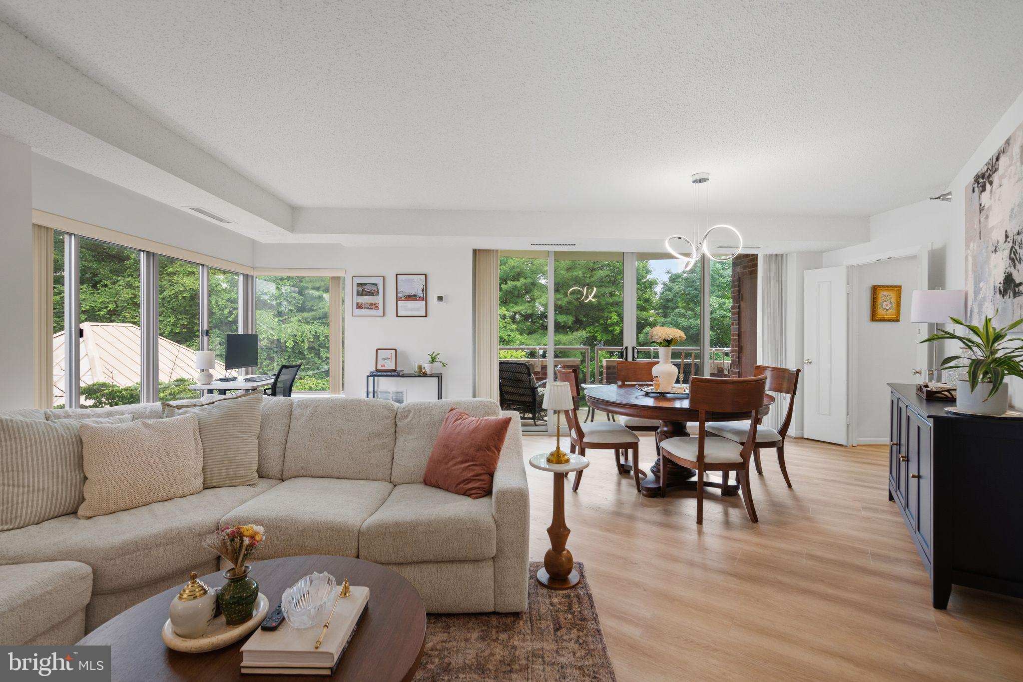 A wonderful opportunity to own a luxury two-bedroom two-bathroom sun-filled unit offering a combination of premium amenities, high-end features, and a central location, as well as two tandem garage parking spaces and new in-unit washer and dryer. Conveniently located in the 5800 building near the amenities and garage, this end unit provides a quiet environment. Featuring high ceilings, expansive windows with natural light and wooded views, and many recent updates and amenities, including new flooring. A dedicated foyer leads to the sunny and spacious living room, which enjoys new sliding glass doors to a private balcony with treetop views. The table-space renovated kitchen is complete with a pantry. 
Each bedroom offers en suite updated full bathrooms, including a primary bath with a walk-in shower and a bonus closet.  Storage abounds with seven closets and a separate storage unit. 

The Fallswood Condominium is beautifully sited within lush landscaping and features well-maintained common areas. Residents have access to a pool, gym, library, and party room. The expansive patio includes gardens, seating, grilling stations, and a tennis court with pickleball lines. For security and convenience, the building provides a 24/7 staffed desk, secure access, an on-site property manager, and an on-site handyman. The social community hosts frequent resident events, and management organizes discounted home services. Additionally, the building is pet-friendly, offers ample guest parking, and ensures efficient snow removal.

5800 Nicholson Lane #307 is conveniently located one block from Whole Foods, CVS, and Stella’s Bakery, and two blocks from Pike & Rose, the Metro, and the Bethesda Trolley Trail. Easily accessible to I-270 and I-495, balancing a residential feel with proximity to major transit and shopping.
