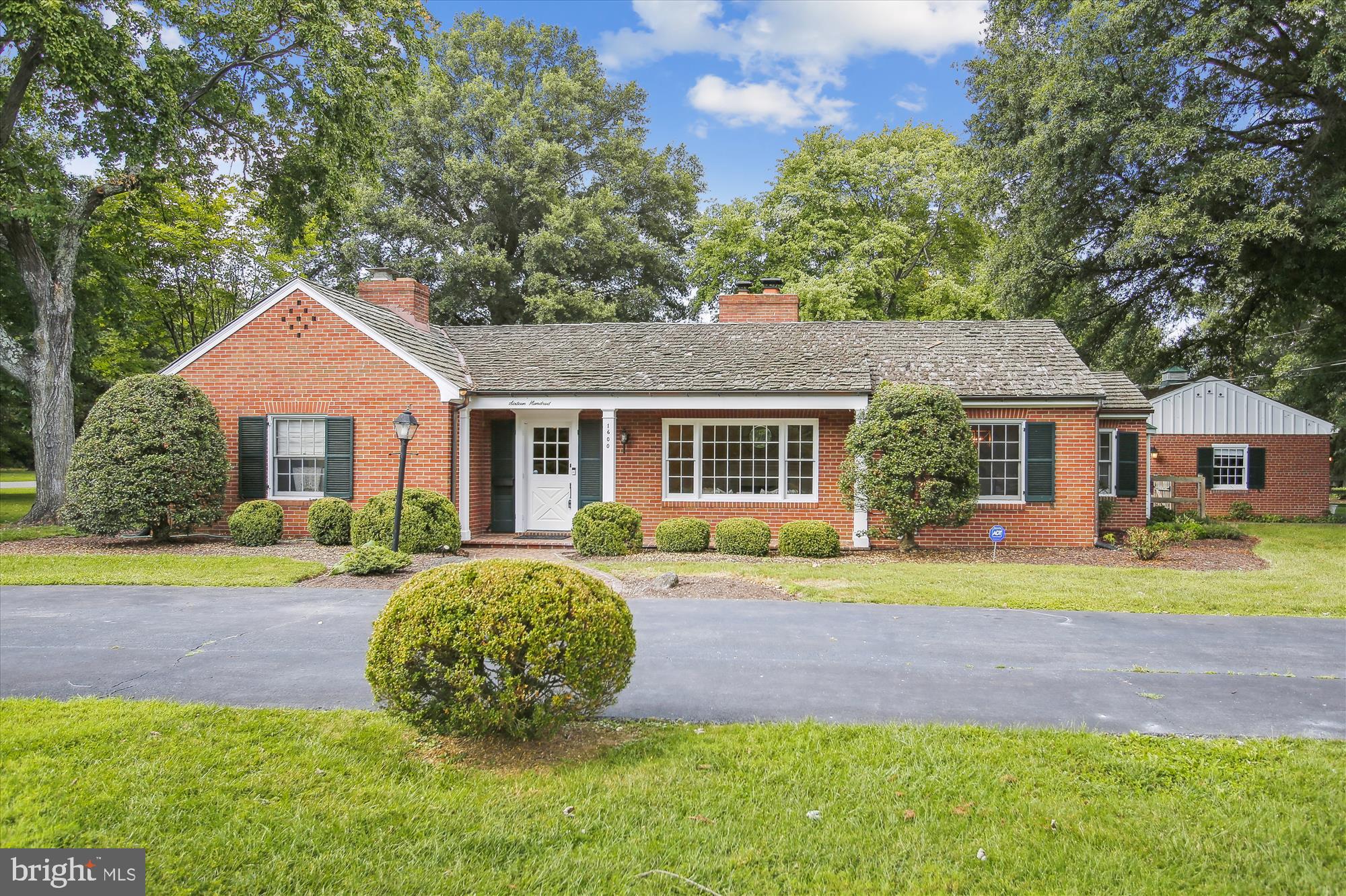 Welcome Home ....This classic all brick home is sited perfectly on a 1.2 acre lot. Every time you drive into your circular driveway, lined with mature English boxwoods, you feel as if you are in the Virginia countryside. This very special home is located in a part of Alexandria that most people don't even know is there. The community consists of a total of eight homes, all of which are on a minimum of one acre. There are strollers, bikers, joggers, dog walkers and the neighbors. Other than that, it's just the delivery folks passing by. It's a private oasis in the city of Alexandria.  The one level living is perfect for scaling down as well as just starting out. The current residents, who have been raising their children there for five years, are moving back to their roots in another state. The original owners resided there for 61 years. Once there, it is very difficult to leave, as it is so unique.  A center hall invites all who enter and separates the living room, dining room and the kitchen from the private sleeping quarters. To the right of the entry, the large living room is flooded with natural light from the expansive south facing window, which is just opposite from the traditional fireplace. The formal dining room is large enough to house all those holiday celebrations. Across the rear of the house is the extremely spacious and efficient kitchen offering yards of marble countertops and painted white cabinetry. A built-in window seat is where much of your time will be spent...whether it's overseeing school projects, everyday dining or just chatting while preparing meals.  Just off the kitchen is a family room with a raised hearth fireplace and beautiful stone floor. This room is perfect for gaming, movie watching and gathering with family and friends. With full access to the rear patio, detached garage and yard, it is very convenient for outdoor activities such as grilling and dining. A convenient laundry and storage room is just off the kitchen as well.  Just on the other side of the hallway you will find four bedrooms and three remodeled baths. There's plenty of room for everyone. The primary bedroom boasts a large shower and double sinks and a traditional marble floor. The hall bath, shared by two of the bedrooms also presents double vanities and plenty of space to move around. The front bedroom, currently shown as an office/study, with its own bath, is ideal for those overnight guests and extended family visits as well.  The magic of this property truly comes alive when you step into the yard, canopied by old Oak trees, and tons of play space. There is a large concrete area that is perfect for a basketball or pickle ball court.  Additionally, you have plenty of space for your own pool, just like five of the neighbors have.  Access to all the major roadways is so close, cutting your commuting time considerably. There are three high schools, two middle schools and one elementary school under construction all less than two miles from this home... making drop offs and pick ups so convenient.