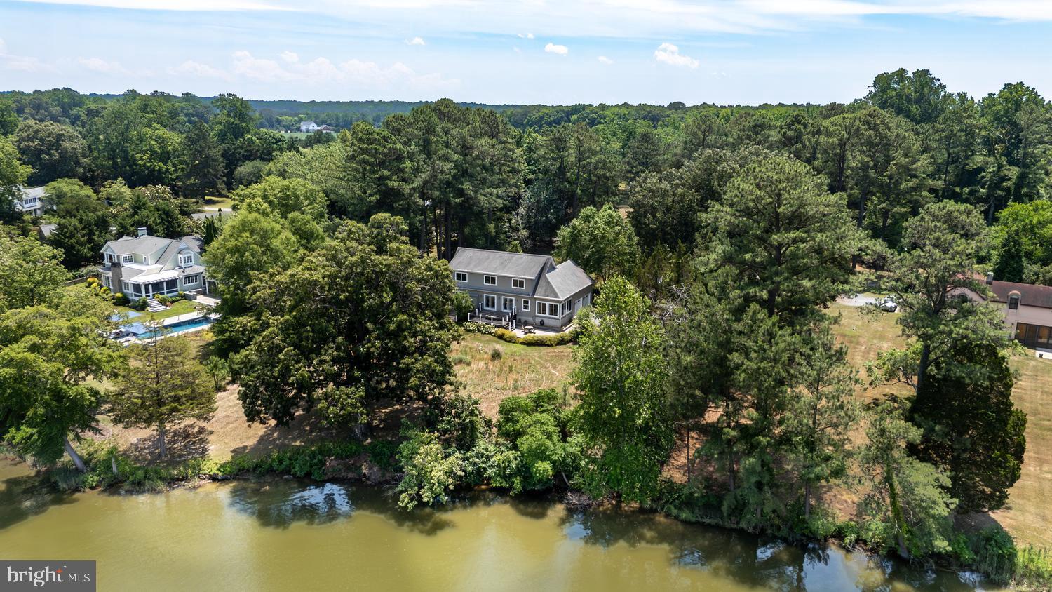 If you are one who expects the unexpected, this waterfront property in Easton will not disappoint. From the one-hundred-year-old oak standing sentinel over Peachblossom Creek to the 42 solar panels creating minimal power bills, this “issue free” home is unexpected, if not actually startling. Ideally located along the desirable Oxford Road corridor, the property offers convenient access to both Easton and Oxford while providing a peaceful waterfront setting on Peachblossom Creek. Designed for comfortable one-floor living , plus full second floor along with  a low-carbon footprint, you can expect a lifetime of enjoyment. This 4-bedroom, 3 full -bath home features beautiful wood floors throughout, a gas fireplace and an eat in  kitchen, and office with built ins and tons of storage space. A huge attached garage provides abundant room for vehicles, hobbies, and storage. There’s even a hot tub! A yard implemented by an expert environmental gardener creates a haven for birds (more than 80 different types of birds can be found here) that is less maintenance—and more attractive to neighbors—than the oh, so very common “all lawn” approach.  Watch bluebirds and herons while you sip your morning coffee from the expansive Azek deck or large paver patio overlooking the water. Smile at lightning bugs flitting about the yard as you watch the stars come out at night from your private rear deck and flower lined patio.. The open floor plan and large windows keep the home full of light and allow endless views of the water. State-of-the-art solar with 2 large Tesla storage batteries,, whole house  water purification system, and HVAC systems make for healthy living, too. A denitrifying septic system  for up to 6 bedroom, helps keep the Bay clean—in fact, this home's low carbon footprint and thoughtfully designed landscape and rain gardens  actually help the environment.  An unforeseen property, even if you expect the unexpected. Beautiful  waterside  sunroom with separate HVAC. Several walk- in storage areas, plus huge unfinished space over garage. Hot Tub and extra freezer convey. Whole house surge protector. Don't miss this fabulous easy low maintenance home. All the hard work is done all that's left is to ENJOY!