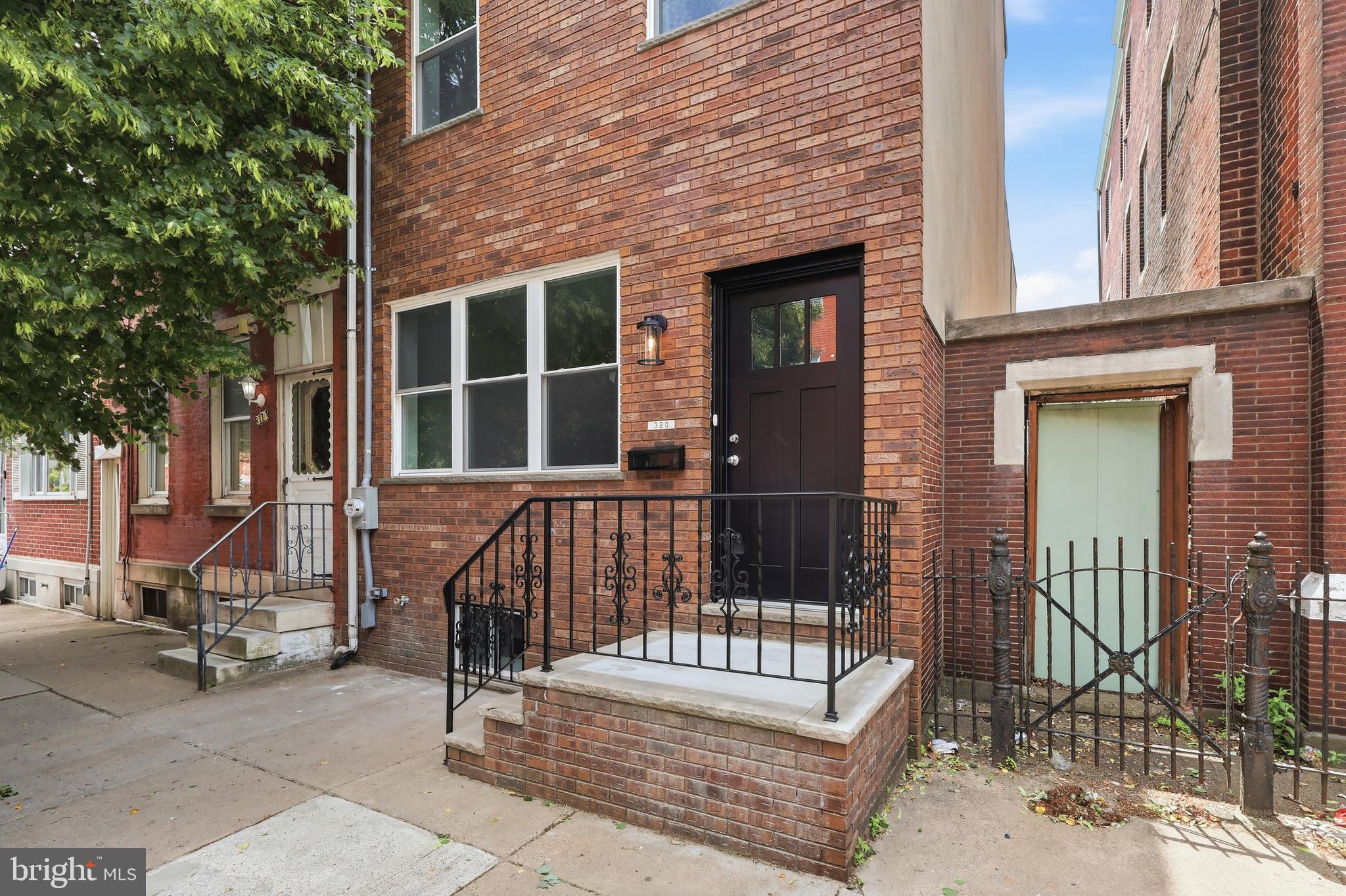 Welcome to 320 Wharton Street — a fully renovated Pennsport gem blending classic Philadelphia character with elevated modern luxury. This thoughtfully redesigned home features wide plank oak flooring, soaring ceilings, recessed lighting, sleek black doors, statement chandeliers, and stunning exposed brick feature walls that add warmth and timeless city charm throughout.

The open-concept main level flows seamlessly into a designer kitchen featuring custom two-tone cabinetry, quartz countertops, stainless steel appliances, open shelving, gold fixtures, and a pot filler. Just beyond the kitchen, enjoy a private rear patio complete with modern horizontal wood fencing — perfect for grilling, entertaining, or relaxing outdoors.

Upstairs, spacious sunlit bedrooms, custom closet space, and beautifully designed bathrooms create a true luxury feel. The primary bath showcases dramatic marble-inspired tile, an oversized glass-enclosed shower, double vanities, and upscale gold hardware, while the additional bathrooms continue the home’s sleek modern aesthetic.

The fully finished basement provides exceptional bonus living space ideal for a media room, gym, office, or guest setup, along with additional storage space rarely found in city homes. Topping it all off is an expansive roof deck with sweeping skyline views and endless entertaining potential.

Situated on a beautiful Pennsport block, 320 Wharton places you just steps from neighborhood favorites like Jax Steaks Taproom, local cafes, restaurants, parks, shopping, and the waterfront, with quick access to Center City, I-95, and Columbus Boulevard.

With a washer and dryer included and a one-year builder warranty for added peace of mind, 320 Wharton Street offers the perfect blend of modern luxury, thoughtful design, and everyday convenience. Don’t miss the opportunity to make this exceptional Pennsport home your own.