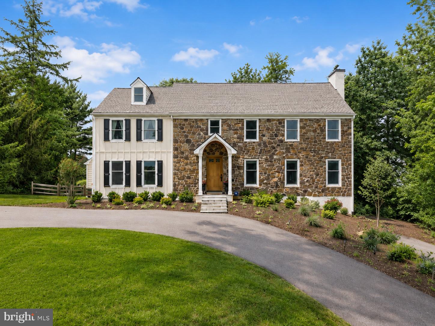 Perched atop one of the highest points in the neighborhood, this private 1.3-acre property enjoys a commanding presence, peaceful views, and a wonderful sense of seclusion. Offering classic Colonial character along with extensive recent improvements, the home feels like a tranquil retreat while remaining close to everyday amenities. With 4 bedrooms, 4 full baths, 2 powder rooms, generous living spaces, and nearly $300,000 in thoughtful upgrades by the current owners, this home beautifully blends timeless character with modern comfort.
A two-story foyer welcomes you inside, where hardwood floors and traditional architectural details set the tone. The main level offers gracious formal and informal living spaces, including a large living room with one of the home’s four fireplaces, all of which have been converted to gas. From here, doors open to the covered porch, creating an easy connection to the outdoors and a wonderful place to relax while taking in the peaceful views of the property. The formal dining room features a large bay window and built-in corner cabinets, while the beautifully refreshed home office, which could also serve as a comfortable family room, features crown molding and a newly updated brick fireplace wall.
The kitchen, fully renovated in 2019, is both functional and stylish, with updated finishes, stainless steel appliances, quartz counters, a separate pantry, and abundant storage. The stone-flanked fireplace creates a warm and inviting setting for everyday meals and casual gatherings. An eat-in breakfast area and convenient wet/dry bar with a beverage fridge, overlook the backyard.  With direct access to the patio, the kitchen becomes a natural gathering place and makes indoor-outdoor entertaining effortless. A laundry room and two powder rooms complete the first floor.
Upstairs, you’ll find four bedrooms, including a spacious primary suite set apart from the other bedrooms. This private retreat features walk-in and traditional closets, his-and-her bathrooms, and the home's fourth gas fireplace. Three additional bedrooms, one with an en-suite bath and two connected by a Jack-and-Jill bath, provide comfortable space for family, guests, or additional office needs. A full walk-up attic spans the length and width of the home, offering exceptional storage and potential for future finished living space.
The finished lower level adds nearly 800 sf of flex space with room for recreation, fitness, and storage. A sauna was installed in 2023, and in 2024, a new heating and air conditioning system was added, and heat was extended to the basement, enhancing the comfort and usability of this level. The attached two-car garage is also accessible from here.
The exterior has been substantially improved and beautifully refreshed. Updates include a full replacement of the previous stucco with Hardie® Plank lap siding, Hardie® trim boards and board-and-batten vertical siding, new gutters,  new shutters, two new chimney caps, a roof portico, new porch columns,  a new blue stone  front porch with slate steps, and a custom mahogany front door, the perfect welcoming entry. The property also features a fenced-in backyard with post-and-rail fencing, newly milled and repaved asphalt driveways with ample guest parking, and new landscaping in the front of the home.
Major upgrades continue throughout the home, including 43 new Andersen 400 Series windows, two new back patio doors, a new water well pump, a water softener system, and conversion from septic to public sewer for added convenience
 Private, updated, and full of character, this home offers the best of both worlds: the charm and presence of a classic Colonial with the comfort of meaningful modern improvements. Ideally located near premier shopping, dining and major commuter routes and just about a mile to Episcopal Academy, this is a truly special property designed for everyday living, easy entertaining, and quiet enjoyment. The family room photo is virtually staged.