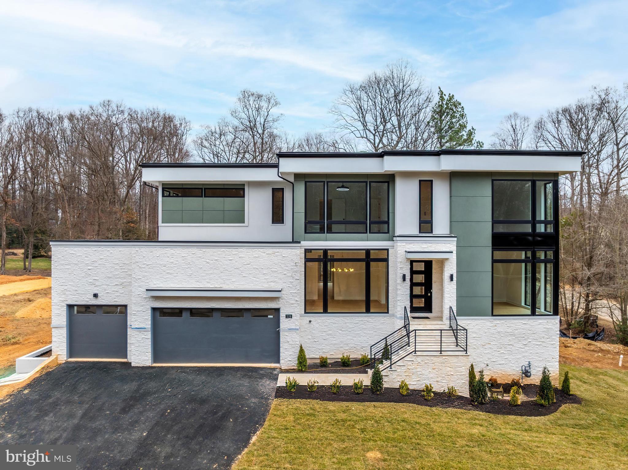 Incredible price improvement!

Welcome to 731 Ellsworth Ave — a stunning custom home by Javlam Homes. Situated on a 1 acre corner lot, this contemporary residence offers over 6,800 square feet of luxurious living across three fully finished levels and is permitted for a future pool or sport court, providing exceptional flexibility for outdoor living and recreation.

Designed with a clean, modern aesthetic, the home is filled with expansive windows throughout, flooding each level with natural light and creating a seamless connection between indoor and outdoor spaces. The main level showcases soaring 10-foot ceilings, wide-plank oak floors, a two-tone custom paint palette, and detailed craftsman-style trim. The spacious family room is ideal for entertaining, featuring a reverse tray ceiling, a sleek 60" gas fireplace, and walls of windows that enhance the home’s airy, contemporary feel.

At the heart of the home is a chef-inspired eat-in kitchen with white shaker cabinetry, soft-close drawers, quartz countertops, and an oversized island perfect for casual gatherings. A full suite of GE Cafe stainless steel appliances including a dedicated beverage center and wine center, along with a well-appointed butler’s pantry, add both style and functionality. The main level also includes a private office or optional bedroom, a full bath, formal living and dining rooms, a stylish powder room, and a custom mudroom with built-in cubbies for everyday convenience.

Upstairs, you’ll find a dedicated laundry room and four en-suite bedrooms, including a luxurious primary suite with a reverse tray ceiling, his-and-hers walk-in closets, and a spa-like bath complete with quartz surfaces, Moen fixtures, and designer finishes. Large windows in every bedroom continue the home’s light-filled, modern design.

The walk-out lower level features 9-foot ceilings, abundant recessed lighting, an exercise room, space for a media room, and a fifth bedroom option with a full bath — offering endless potential for recreation and relaxation. Step outside onto the Trex deck overlooking a yard to be professionally landscaped in the coming weeks, with ample space for a pool or sport court—ideal for entertaining, play, or peaceful retreat.

Located in the sought-after Langley High School pyramid and just minutes to Great Falls Park, Tysons Corner, I-495, and the GW Parkway, this exceptional home offers a rare combination of modern design, natural light, and future outdoor potential, all with the privacy and convenience of one of Great Falls’ most desirable locations.