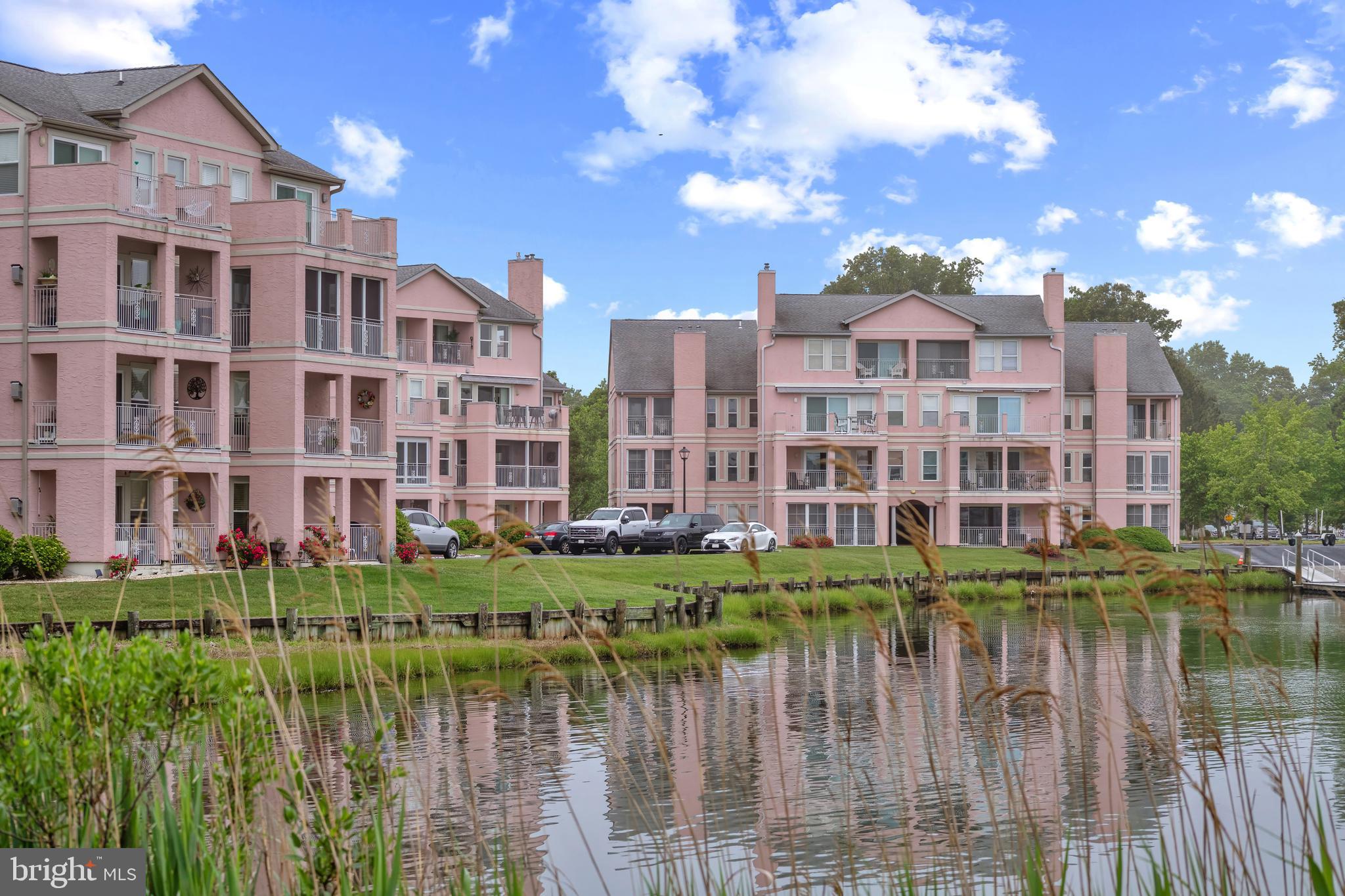HUGE PRICE ADJUSTMENT!  This is it! Beautiful view overlooking Yacht Club Marina, across the Bay to Ocean City skyline! Take the elevator to the second floor to view this stunning home that is as gorgeous as it is convenient to neighborhood amenities.  Enter into the wide foyer boasting a niche with shelving to display your pretty things. The walk-in laundry/utility/storage room is a wonderful surprise. Cooking in the kitchen is a delight with stainless appliances and a gas range. Plenty of storage in the custom painted cabinetry and pantry.  Gleaming granite countertops with a bar into the dining room. A large spacious living room opens to an amazing view overlooking the water and has a gas fireplace for cool evenings.  A large three season sunroom with a spectacular view all the way to Ocean City.  Separate walk-in storage located on the same floor as the unit. The current homeowner has lovingly maintained and updated this home. Newer hot water heater, HVAC, windows, ceiling fans and more! Walk to Mumfords Landing pool, the Yacht Club for dinner and entertainment. Enjoy everything Ocean Pines has to offer - swimming pools, tennis & pickelball, golf course with Club House, Beach Club (ocean front with parking and restrooms), dog park, skating park and too many clubs and social activities to mention!  Call me for a private showing!