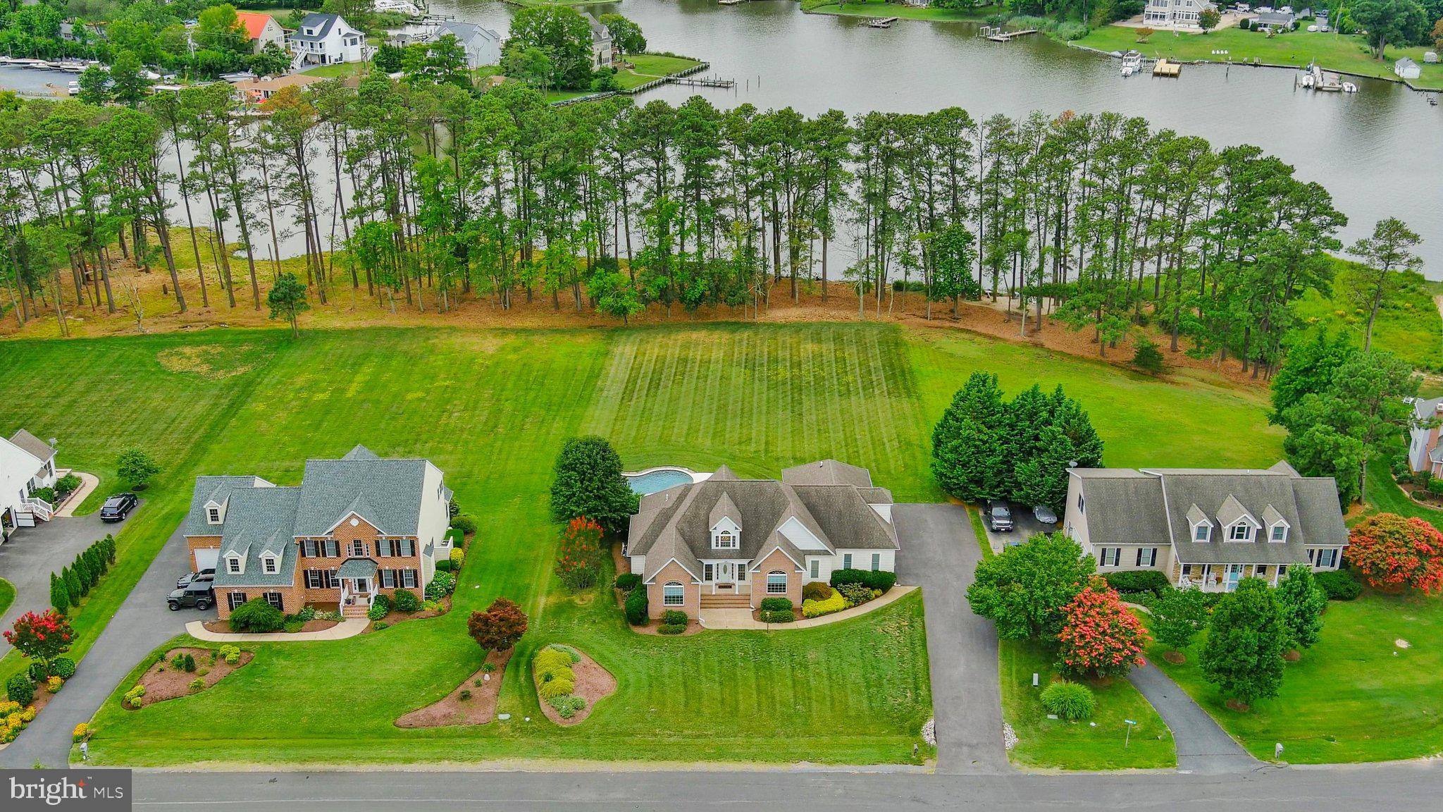 WATERFRONT LIVING on Winchester Creek! This wonderful 4 bedroom, 2.5 bath Grasonville estate offers the ultimate Eastern Shore lifestyle, fully refreshed with a newly painted neutral interior, gleaming refinished hardwoods, and carpet. A grand 2-story foyer with a palladium window, transom accents, and elegant French doors welcomes you inside. The main level features 11' ceilings, a great room with fireplace and a bank of windows with water views, a separate dining room, bright breakfast room, and a fabulous kitchen with an island, pantry, and reverse osmosis water filtration. The main floor primary suite boasts a walk-in closet and a no-threshold shower, complemented by a full, hall bath and convenient half bath. Upstairs, a versatile bonus space features custom built-ins— perfect for an office and media space. Your outdoor resort awaits: a Trex deck with built-in benches and retractable awning leads to a custom paver patio and a sparkling 18’ x 37’ saltwater pool with a tranquil waterfall feature. Boaters will love the deeded boat slip (#10), mooring pile, and private boat lift. Rounding out this incredible home is an oversized 2-car garage with storage space, HVAC (2018), buried 500-gallon propane tank, and full water conditioning system and lush landscaping.