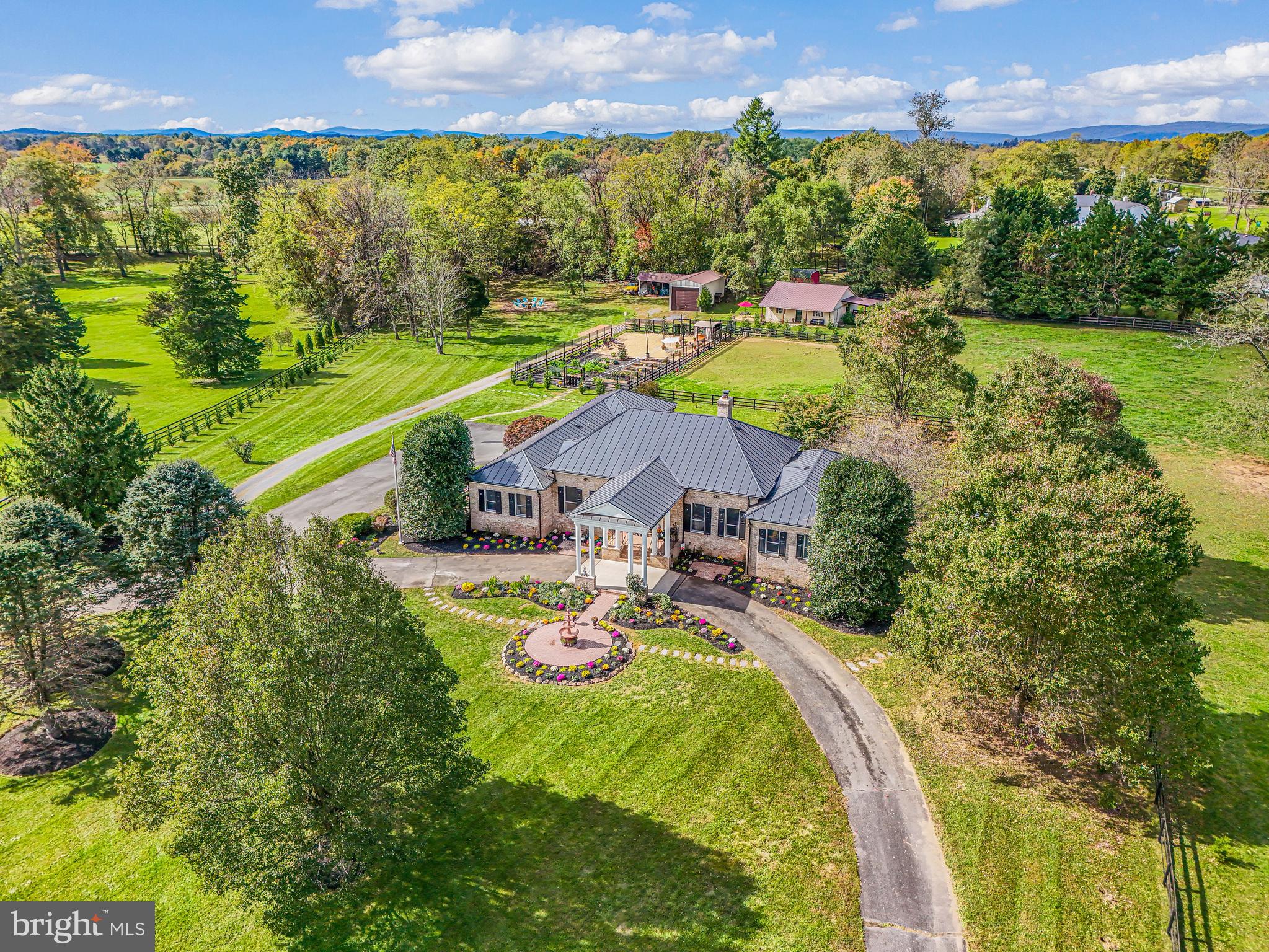 Fox Hill Farm sits just over a mile east of historic Middleburg, offering a rare chance to own a beautifully remodeled estate that blends refined living with true Virginia equestrian charm. Set on 7.6 picturesque acres and reached via paved Four Chimneys Lane off Little River Turnpike, the property offers 6,547 finished square feet across the main residence and barn apartment. The elegant two-level brick home features a main-level primary suite with a spacious walk-in closet incorporating a second laundry, plus two additional bedrooms each with its own en-suite bath. A gracious foyer opens to formal living and dining rooms, while the expansive gourmet kitchen, anchored by a grand center island, flows into a bright breakfast area and light-filled great room with a striking Palladian window framing views of the paddocks and barn beyond. A side-loading two-car garage completes the main level. The recently finished lower level offers a home theater, recreation room, library/office, sitting room, full kitchen, wet bar, full hall bath, laundry, and two additional en-suite bedrooms, with walk-out access to a rear patio overlooking the landscaped grounds. A separate driveway serves the fully remodeled guest cottage and barn, currently operating as a short-term rental, complete with an oversized detached garage. Additional features include a fenced kitchen garden, outdoor gathering area, and potential for an accessory dwelling, subject to approvals. A truly special Middleburg retreat.