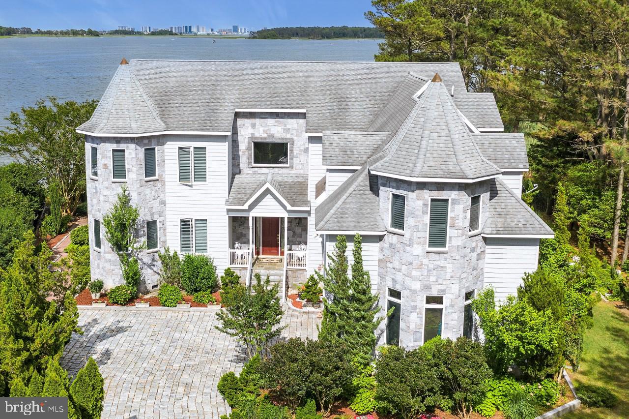 Welcome to your own Private Paradise! Known as the Castle House, this stunning residence is sited at the mouth of the St. Martins River and overlooks Isle of Wight Bay with stunning views of the Ocean City Skyline in the distance. Walk down your private sandy beach to the 120 foot pier with boat lift and spend the day cruising the bay, visiting the many bay side restaurants and bars. For the fishing enthusiast the nearby in-shore and off-shore waters will not disappoint. You may not want to leave this private estate with all it has to offer, gourmet kitchen, exceptional rooms for entertaining, expansive waterfront views, 5 bedroom suites and 1  huge dormitory style room for the kids that sleeps 8, 6 and one half baths, beautiful finishes including Swarovski Crystal Chandeliers and cabinet knobs. Step out onto the huge rear deck and take a swim in the 30x18 pool. Enjoy watching wildlife? This home boarders 10 acres of forest preservation! Located in the prestigious community of Harbor Village in Ocean Pines, this residence is just a few short hours from the DC and Baltimore metro areas. Please contact agent for a detailed list of features and for your private tour of this amazing property.