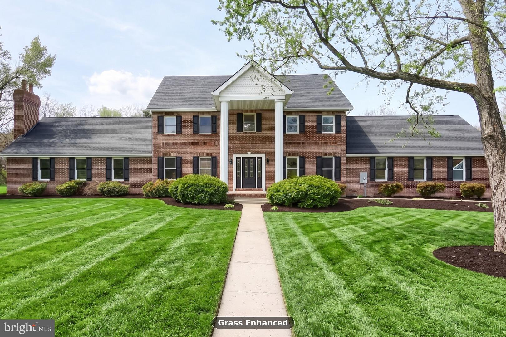 Welcome to 1070 Fish and Game Rd., a fully renovated 8-bedroom, 4.5-bath luxury estate set on just under six private acres in the Bermudian Springs School District. Rolling farmland, long mountain views, and mature redbud trees frame the approach, while a classic brick colonial silhouette — white two-story columns, black shutters, a central portico, and a white picket fence — sets the tone at the curb. The renovation goes far deeper than finishes. Every major system has been addressed: a brand new architectural shingle roof, new HVAC, updated plumbing and electrical, and a recently serviced well and septic. The result is a true move-in-ready estate with nothing left to chase.

Inside, the home lives bright, open, and entirely new. Wide-plank flooring, crisp white walls, fresh trim, and designer lighting carry from room to room. The chef's kitchen is the centerpiece — a waterfall quartz island with Calacatta-style veining, two-tone Shaker cabinetry, matte black faucet and range hood, a geometric tile backsplash, a full stainless appliance package, and a statement chandelier over the prep space. The kitchen opens to a bay-window breakfast nook and flows into an oversized living room anchored by a wood-burning brick fireplace with flanking built-ins. A formal dining room with wainscoting and classical columns, a cherry-wood office and butler's pantry, a laundry room with quartz counter and utility sink, and a sunroom with cathedral ceiling round out the main level.

The primary suite is genuinely massive — spanning nearly the full length of the wing, with walk-in closets and a spa-level ensuite clad in book-matched marble slab, outfitted with a freestanding soaking tub, a glass walk-in shower with rainfall and wall heads, brushed brass fixtures, and a fluted-wood double vanity. A main-floor second bedroom and a second-floor ensuite bedroom create true multi-bedroom single-floor living and flexible layouts for extended stays, visiting guests, or a dedicated home-office wing. A true third story adds two additional large bedrooms and another full bathroom — ideal as a private guest wing, teen suite, or hobby floor — with a dark-stained staircase and turned balusters tying all three levels together.

Outside is where the property really separates itself. A brand new oversized stamped-concrete patio and a full-width composite deck extend the living space across the entire rear elevation — built for large gatherings, outdoor dining, and quiet evenings with uninterrupted views. A 3-car oversized attached garage, a large green pole barn with electric service for workshop or storage use, and a fully paid-off solar array — sized to run the entire home and bank credits for any overages — make this a rare combination of luxury, acreage, and long-term efficiency. A full unfinished basement rounds out the package with significant future expansion potential. Turn-key, top to bottom, inside and out.