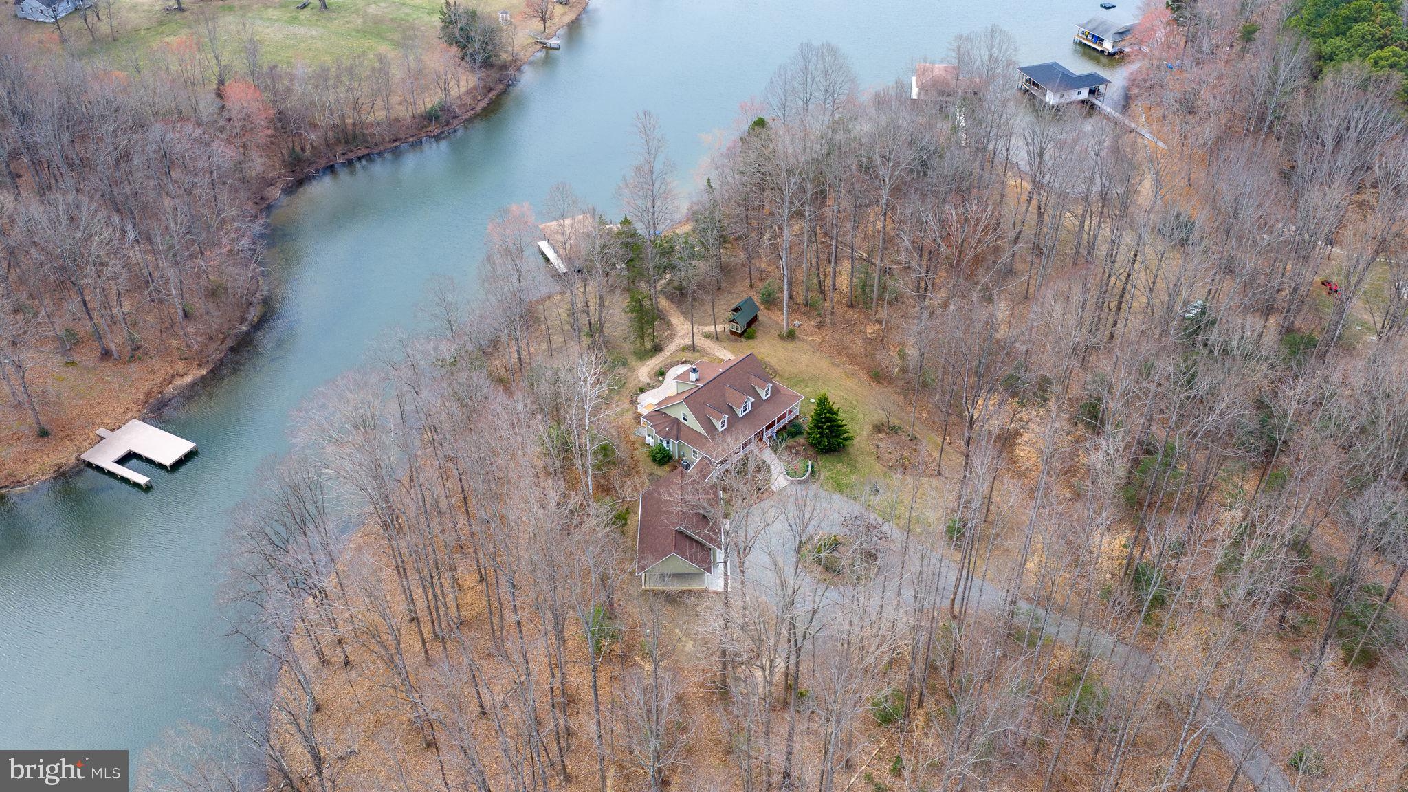 Welcome to 3900 Water Front Court on the Public (cold) Side of Lake anna.  Located in  the community of Sycamore Shoals.  

 Built in 2011, this beautiful custom home is located on a quiet cul-de-sac.  Over 4000 sq ft. across 3 levels

 Follow the driveway up and around the circular drive to arrive at the house.  Plenty of parking and easy and access to the garage.  A beautiful Cape Cod style house with a covered wrap around porch and a simi detached garage that joins the house by a covered walkway.  This home has wonderful flow from one room to the next for easy movement through the house.  

Home features 2x6 exterior wall construction,  high ceilings and lots of windows to let in the natural light.  A wall of windows facing the lake greet you when you enter the home.  A main level primary bedroom with ensuite has double vanities, a soaking tub, and a walk in shower.  Full bath on each level, 2 on the main level.  2 bedrooms and a bathroom on the upper level.   Kitchen has a gas stove and a double oven.  The laundry room is conveniently located next to the kitchen.   The home has 2 fireplaces.  One gas fireplace on the main level in the living room.  One wood burning fireplace on the lower level in the family room.  Living room, den/guest room, dining room, eat in kitchen on the main level.  Family room with wet bar and a large storage room on the lower level. The lower level is walkout to grade.  New carpet on the main level.   2 water heaters and 2 HVAC systems.  The 2nd of each can be turned off at the breaker when demand is low.  
The oversize garage features 2 parking spaces inside and a carport outside.  There is an unfinished space above the garage that is accessed by the inside staircase. Finish the space or use it for walk up storage.
There is an adorable potting shed in the back yard.  Ample room for a mower, tools, and planting supplies.  
Down to the water the shoreline has been left natural.  The boat house has 2 slips.  Each has an electric lift.  The boathouse has a locking storage closet, screened porch and a large deck that covered as well as an uncovered portion for soaking up the sun.

The homeowner is an avid gardener, so the yard has been planted with native perennial plants that fill the yard with color all spring and summer long and for each year to come

This property offers calm waters in a quiet cove with the main lake right around the corner.

Don’t miss out on your chance to call this beautiful home  yours.