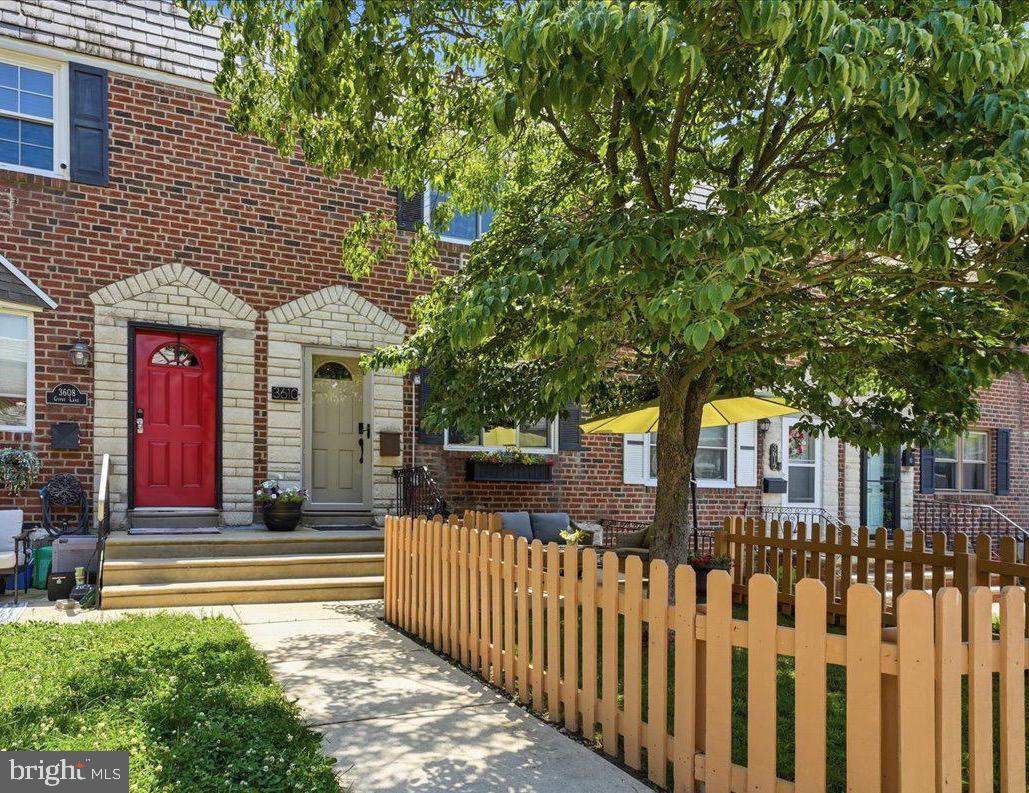 Welcome to 3610 Gypsy Lane, a beautifully maintained brick townhome nestled on a quiet, tree-lined street in the heart of East Falls. Thoughtfully updated over the years and impeccably cared for, this move-in ready home offers the perfect blend of modern comfort, inviting living spaces, and exceptional indoor-outdoor living. Step inside to a bright, welcoming living room accented by crown molding, recessed lighting, and luxury vinyl flooring that flows seamlessly into the stunning renovated kitchen and dining area. Designed for both everyday living and entertaining, the kitchen features warm wood cabinetry, quartz countertops, stainless steel appliances, a subway tile backsplash, gas cooking, and an oversized center island with abundant prep space and seating. Sliding glass doors extend your living space to an expansive rear deck complete with a gas hookup for grilling and plenty of room for dining, relaxing, and entertaining. The second floor offers three comfortable bedrooms, including a spacious primary bedroom, an updated full bath, and brand-new luxury vinyl flooring installed in 2026. One of the secondary bedrooms is perfectly suited as a nursery, guest room, or dedicated home office. The finished walk-out lower level provides valuable additional living space ideal for a family room, fitness area, playroom, or media room, along with a beautifully updated powder room, laundry area, extensive storage, and direct access to the private rear driveway with off-street parking for one car.  Outside, enjoy two distinct outdoor living spaces—a charming fenced front yard shaded by a mature tree and an expansive rear deck that creates the perfect setting for summer gatherings. Few city homes offer this combination of outdoor space, flexibility, and parking. Extensive improvements provide exceptional peace of mind, including a new roof (2025), renovated kitchen and bath, replacement windows, furnace (2015), central air (2016) with new condenser fan (2024), water heater (2021), fencing, concrete walkways, interior doors, washer, dryer, dishwasher, deck improvements, and more. Ideally located just minutes from Center City, Kelly Drive, Fairmount Park, SEPTA Regional Rail, major highways, neighborhood restaurants, cafés, and the vibrant East Falls business district, this turnkey home offers the perfect balance of neighborhood charm and city convenience. Whether you're hosting friends on the expansive rear deck, enjoying a quiet morning coffee beneath the shade of the mature front yard tree, or taking advantage of East Falls' parks, trails, and neighborhood favorites, 3610 Gypsy Lane offers a lifestyle that's as inviting as the home itself.