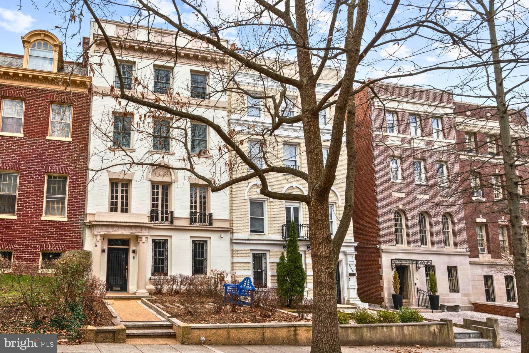 This stately residence was built circa 1917 and recently renovated throughout.  The home encompasses over 4,600 square feet of interior living space with generously-scaled formal entertaining rooms, as well a comfortable family living spaces. The four-story townhouse features a traditional brick façade accented with limestone, offering a glimpse of the timeless elegance that lies within. The floorplan has been thoughtfully expanded and meticulously updated to incorporate attractive finishes, with the added benefit of an elevator servicing all levels. 
The gracious foyer is adorned with sophisticated plaster walls, elegant moldings and trim setting the tone for the home’s timeless design. This space flows effortlessly into a first-level library or office, which features expansive built-in shelving, a fireplace and a sleek glass sliding door that allows for natural light to fill the room. This level also includes a stylish modern kitchenette, a convenient powder room, and plenty of closet space for added functionality. There is also easy access to the attached one-car garage and a side entrance to the rear of the property from this floor.
The grandeur of the home continues with a beautiful staircase that ascends to the Italian inspired “Piano Nobile” style formal living room located on the second floor of the residence. This generously-sized room boasts high ceilings, a marble fireplace, and is illuminated by three oversized windows. Original architectural details enhance the room’s character, adding timeless character to its modern updates. The gracious dining room, ideally situated adjacent to the gourmet kitchen, sets the stage for refined gatherings. The well-appointed kitchen has been beautifully updated to include high-end appliances and extensive cabinetry. It seamlessly transitions to a wrap-around deck—perfect for al fresco dining and outdoor entertaining. 
The expansive primary suite, located on the third floor, offers a luxurious retreat with generous proportions and thoughtful features, including custom built-ins, a walk-in closet, and an additional sliding-door closet. The suite is complemented by a large bathroom which connects to a private office and adjoining exercise room. The adjacent laundry room adds practicality and ease, completing this floor. 
The fourth level has three thoughtfully designed bedrooms, with the largest offering an elegant en-suite bathroom. The other two bedrooms are spacious and share easy access to a beautifully appointed hall bathroom. The third bedroom also offers a private deck, creating a peaceful outdoor retreat. This distinguished residence is amongst many ambassadorial homes and many of the District's most historically and architecturally significant properties. It is centrally located and is walking distance to Georgetown, Rock Creek Park, and the White House. This home is an exceptional offering in the heart of Kalorama.