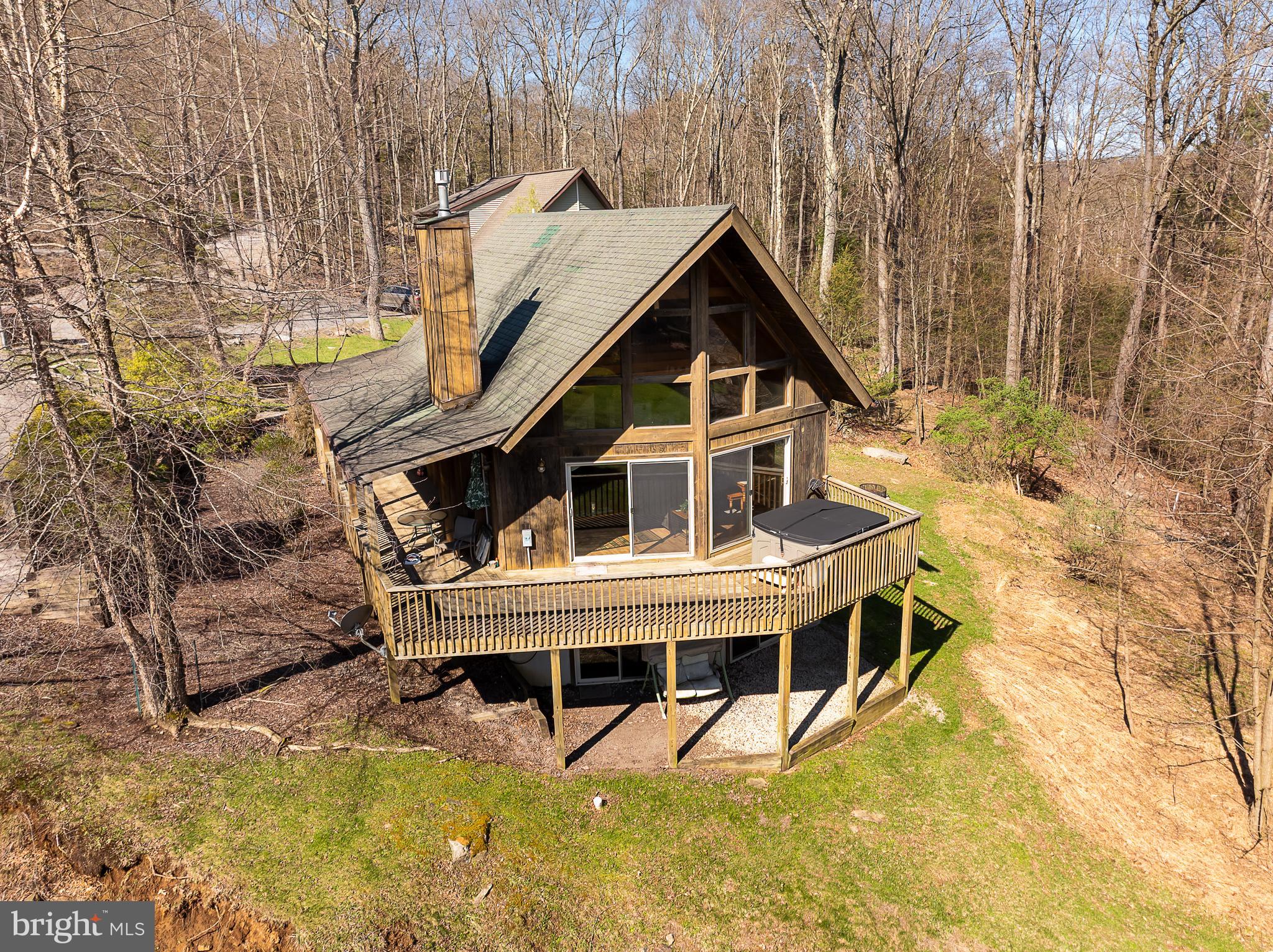 3/4BR 3BA chalet with LAKE VIEWS! 2300sf vacation home fronting on a mountain stream, overlooking Deep Creek Lake! Enjoy an eat-in kitchen, exposed beams and a loft area that the current owners use as a 4th BR with bathroom. NO HOA! Conveys fully furnished. Features include central AC, exposed beams, updated flooring, gas fireplace on main level, lower level rec room with pool table and wrap-around deck with hot tub. Central location near 219 bridge, close to Wisp & local restaurants, entertainment and shopping.