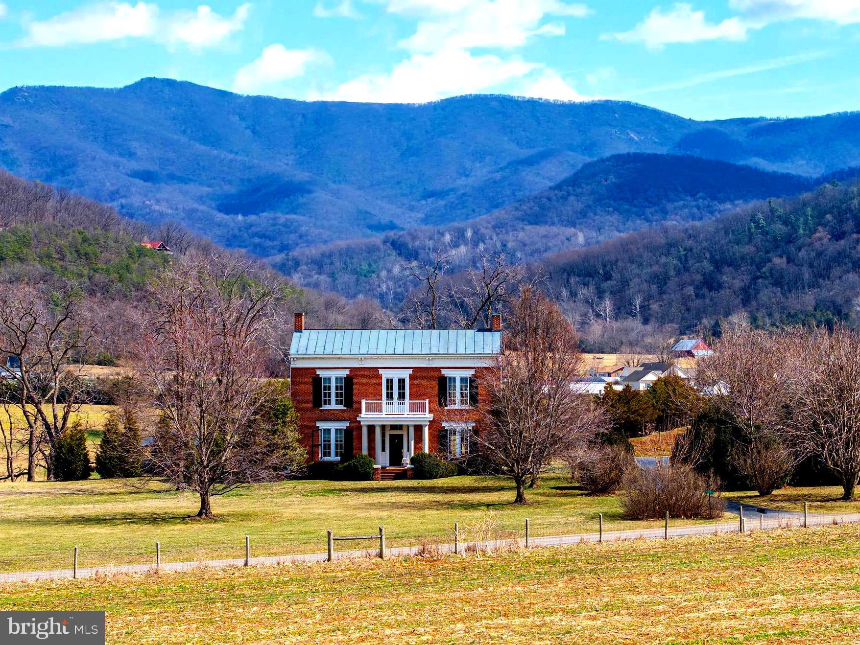 Rare opportunity to own a beautifully restored historic brick farmhouse in the Shenandoah Valley with proven short-term rental success and strong investment potential. Known as the Joseph House (and as the Koontz-Cave House), this circa-1845 Greek Revival home, listed on the National Register of Historic Places, blends timeless architectural character with thoughtful modern updates to create a truly unique residence, retreat, or income-producing property. The home features four bedrooms and three and a half bathrooms, along with multiple inviting living spaces that showcase its historic design. Interior spaces include a formal dining room, parlor, library, pantry, laundry room, and a full modern kitchen, all complemented by elegant architectural details and a grand central staircase. Gas fireplaces throughout the bedrooms, primary bathroom, and main living spaces add warmth and character while preserving the historic ambiance of the home. The main level offers comfortable gathering spaces including the kitchen, dining room, parlor, library, and powder room, along with inviting outdoor areas including a partially covered side porch and a fully screened rear porch, perfect for relaxing or entertaining. The second level includes three bedrooms and three bathrooms, one of which is a spacious primary suite with a claw-foot soaking tub, creating a peaceful retreat within the home. Situated in a scenic Shenandoah Valley setting, the property enjoys magnificent mountain and pastoral farm views, creating a peaceful and picturesque backdrop that guests and visitors consistently appreciate. The home has demonstrated strong short-term rental performance, benefiting from the region’s thriving tourism market and steady demand for unique historic lodging. The location is especially appealing for visitors attending events, as the property sits near multiple highly sought-after wedding venues, making it a popular lodging option for wedding parties and guests. The combination of historic charm, scenic surroundings, and convenient access to event venues contributes to the property’s continued success as a vacation rental destination. Conveniently located approximately two hours from Northern Virginia and Washington, D.C. and about 90 minutes from Charlottesville, the home offers easy access via a paved state-maintained road while still providing a tranquil countryside setting. Outdoor recreation and tourism opportunities abound nearby, including the Shenandoah National Park, Skyline Drive, the Shenandoah River, wineries, hiking trails, fishing, Massanutten Resort, Luray Caverns, and other popular Shenandoah Valley attractions, all within a short drive. Whether you are seeking a historic residence, private retreat, or proven income-producing short-term rental, the Joseph House offers a rare opportunity to own a piece of Shenandoah Valley history combined with exceptional character, scenery, and investment potential.