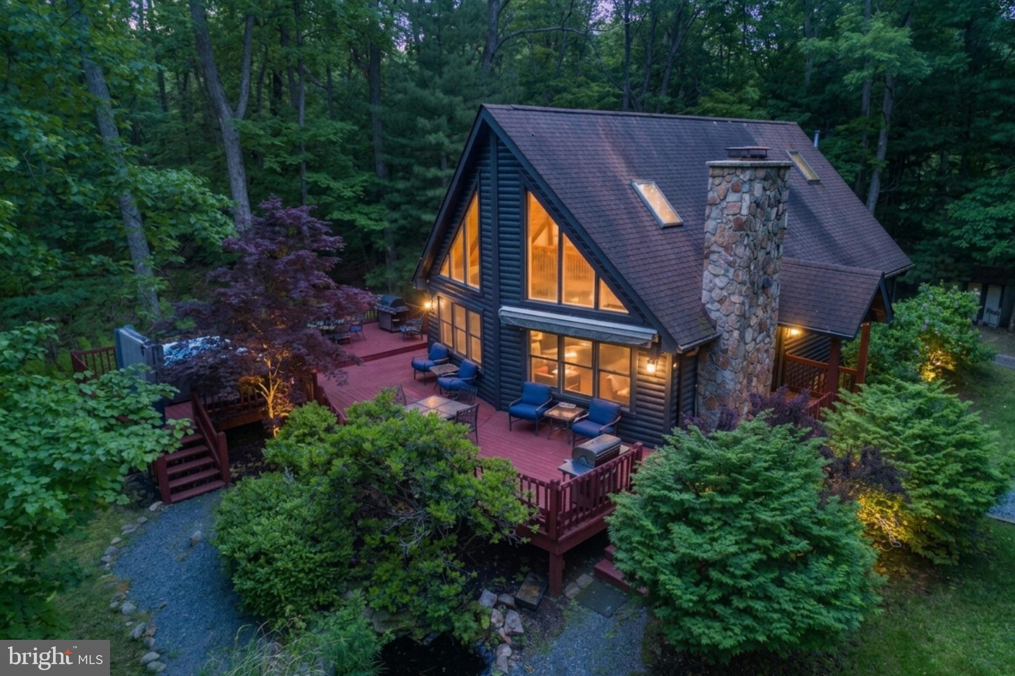 Picture perfect, private and wooded mountain retreat featuring lake access in a prime location close to all area amenities!   Seasonal lake views!  This highly desirable property offers the opportunity to walk to your dock featuring TWO slips for your use. A two-minute walk  at the end of the quiet road leads you to the property's deeded lake-front land and two dock slips.  Nestled among the mountains, the home combines a private, peaceful setting with convenient access to everything the area has to offer. Inside, the open floor plan is filled with natural light and creates an inviting space for gathering and entertaining. The home features 4 bedrooms and 3 full baths, providing plenty of room for family and guests. Enjoy relaxing evenings in the hot tub or around the outdoor firepit after a day on the lake.
Recent improvements include a new roof, beautiful hardwood flooring, Culligan water filtration/softening system, new kitchen countertops and sink, and a new hot water heater installed in winter 2026.  Turnkey with newer furnishings, beds and washer/dryer.  Thoughtfully updated and well maintained, this property is ready to enjoy as a full-time residence, vacation getaway, or investment opportunity.  Currently a Vacation rental "Swimming Bear Lodge"