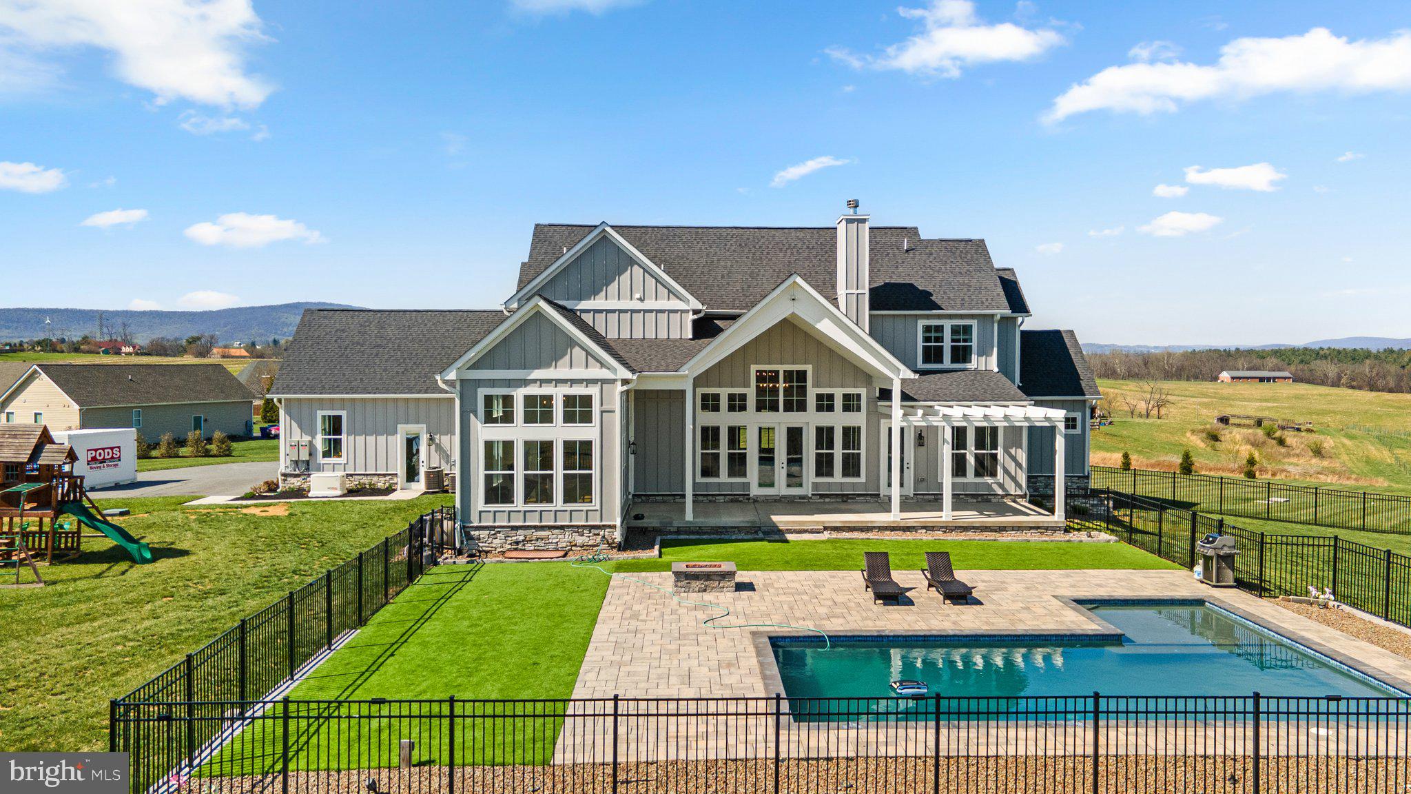 This stunning custom-built home blends timeless style with elevated modern finishes—inside and out. From the moment you arrive, you're greeted by a charming & spacious front porch, and panoramic mountain views that set the tone for what's inside.

Step into a show-stopping great room with vaulted ceilings, a statement brick fireplace, and a full wall of windows flooding the space with natural light. The chef’s kitchen is equally impressive, featuring an oversized island, high-end appliances, soft-close cabinetry, and designer backsplash. The dining room features a vaulted ceiling and walls of oversized windows- Direct access to the patio and pool area makes it perfect for entertaining. Large walk-in pantry offers exceptional storage with custom shelving systems, multiple levels of organization, and space for small appliances, bulk items, and cleaning tools. Also located on the main level is a well-appointed mudroom with direct access to the 3-car garage, custom drop-zone storage potential, and an additional laundry hookup for added flexibility. A stylish half bath is conveniently located for guests, and a dedicated home office sits just off one wing of the dual primary suite—ideal for those who work from home or need a quiet retreat.

The main-level primary suite is generously sized and positioned for privacy and convenience. This spacious retreat features 10-foot ceilings, recessed lighting, and large windows that provide natural light. Complete with sitting area that leads to the back patio.

The main-level primary bathroom is a unique retreat, boasting dual "his and her" wings with vanities and walk-in closets, meeting in the middle at an oversized shower with designer tile, and a spa-like vibe. 

Upstairs, you’ll find two generously sized bedrooms connected by a Jack-and-Jill bathroom, featuring separate vanities on each side of the shared bath. A third upstairs bedroom is served by a full hall bath, ideal for guests or additional family members. Just off the landing is a versatile flex space, perfect for a teen hangout, playroom, secondary office, or quiet reading nook—designed to adapt with your lifestyle.

The fully finished walk-out basement offers incredible versatility and nearly a home within a home. With two additional bedrooms and two full bathrooms, it’s perfectly suited for guests, extended family, or multi-generational living. A spacious entertainment zone anchors the level with a large media area, game space with ping pong and billiards, and a full wet bar featuring sleek cabinetry, quartz counters, and a beverage fridge. There’s also a dedicated office for those working or studying from home.

Step outside to your private oasis—where a heated saltwater pool, pergola-covered patio, and professionally landscaped yard await. Whether you're lounging by the pool or enjoying a quiet evening by the fire pit, this home was built to impress in every season.

Don’t miss the rare opportunity to own a home that combines luxury, function, and panoramic views in one of Middletown’s most sought-after settings. Additional recent upgrades include a whole-house generator and top-of-the-line water filtration system.