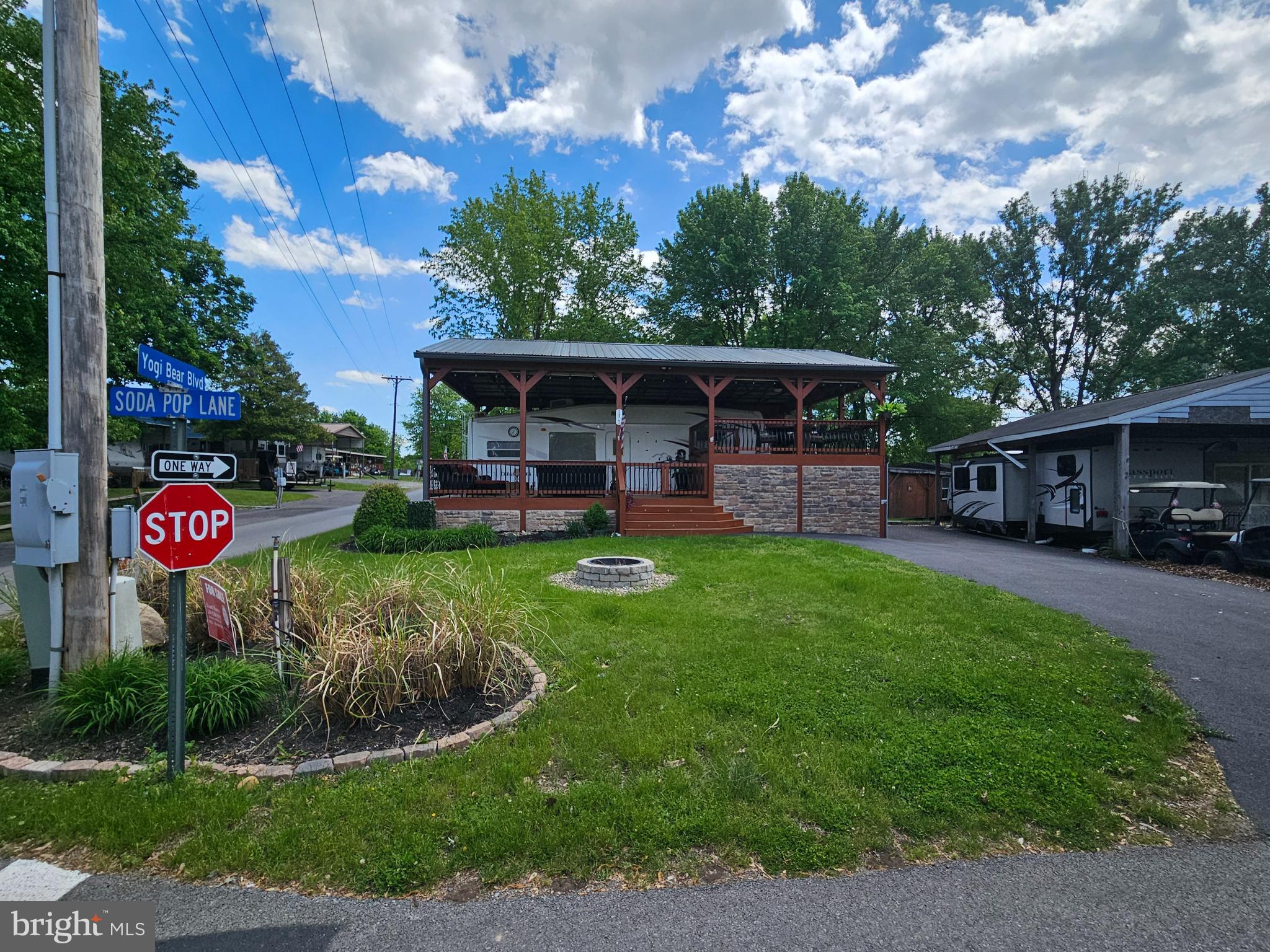 Motivated Sellers. 
Situated on the corner of Yogi Bear and Soda Pop sits a property so meticulously taken care of and thought through property with SEWER! Beautifully landscaped & has Frontier internet. 

Talk about Home away from home! Make this spot your seasonal getaway in Riverbends Campground. Riverbend is 400 Acres of SEASONAL recreational campground full of amenities located on the Potomac River in Falling Waters, Wv.  Within a drivable distance to most of the Quad state area. 
OPEN APRIL 1 - NOVEMBER 1 - This is a fun & entertaining community, yet relaxing. Financing Could be available. They require a minimum of 25% down of purchase price or appraised value. 

Massive Stick Built Pavilion with a metal roof, gutters, downspouts and fully wired with electric for all the needs including a wired Generator plug! Walk right up through the wide staired, double gated entry to the porch. This outdoor oasis is spacious enough to be the hostess with the mostest with a 2-level deck surrounded by patio lights, sunshade blinds, and seating for many. You'll definitely want to make your memories here. The entire back side of the upper deck has a bar with bar seats and its own outdoor side by side refrigerator and new Ice maker line installed to keep those drinks cold all season. These owners have thought of it all. Equipped with lighting systems through all the stairs, patio, 3 ceiling fans with lights keeping that hot summer air flowing on timers and with remotes for the fans. You really must see all these features in person to appreciate. Over 300 metal balusters and glazed stonework around the foundation giving the deck a more luxury feel. The driveway is paved and has ample parking; a flat yard centers a block firepit for those campfires and s'mores. Housed under this 12 Ft + tall pavilion is a '04 5th Wheel Cedar Creek camper that also has some upgrades including a new larger Magic chef fridge, 8 all new LED light system that has 3 color tones to choose from, 2 Smart Tvs, a new receiver system that is wired to 2 speakers outside for your music and Tvs as well as providing audio inside the camper. The bedroom is a queen size bed with extra storage, Stall shower and bath in the upper part, sofa sleeper in the living room. Under the top deck is a well thought out garage workshop area big enough to house a small car or the 2017 Lifted Ez Go Golf cart that conveys with a full offer. It also has a radio & speaker system, under glow lights and more. Real Nice. The garage has a block foundation and concrete floor as well as Pvc panels on the ceiling that connects to downspouts to keep rainwater out. Lights and outlets all wired for your workshop needs with cabinets. 100G Propane tank, Deck Box, All Patio Furniture, Bike racks, Tool Racks all convey. Join the Riverbend Boat Club. Call today for your personal tour. Approx. 10 miles of Deep water on the Potomac River access for boating, fishing & swimming. Yearly membership ($1,987) plus a $200 initiation fee for new owners, includes water, sewer, electric, trash and the park amenities such as 3 pools, putt putt course, Horseshoe club, Boat club, Poker runs, Trick or Treat, Christmas in July, live bands, basketball court, tennis court, fireworks, car show, Church, restaurant, bar, convenience store (Great food), playground, volleyball, ball field and much much more. Bring your golf carts, water toys and come enjoy life!