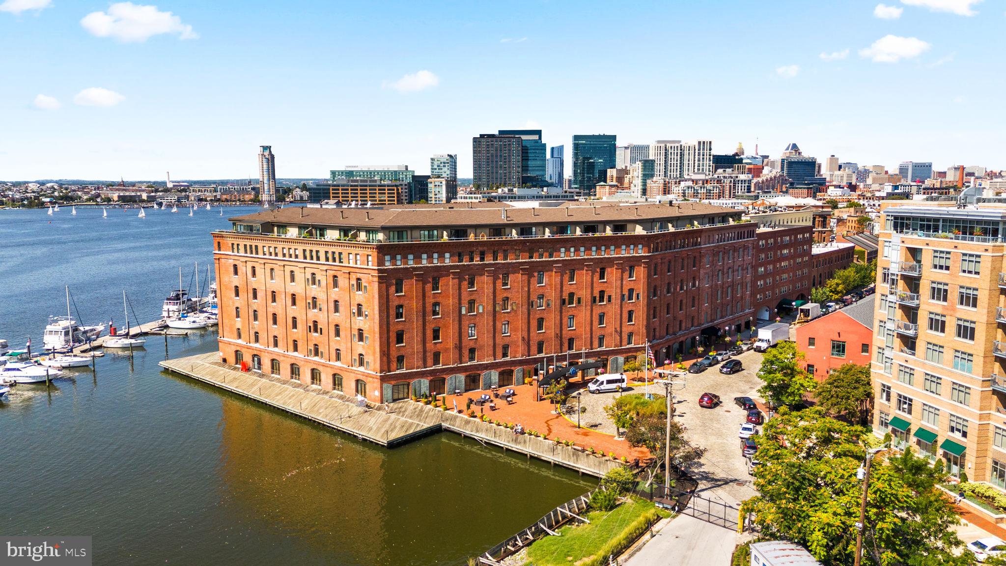 "***PRICE REDUCTION***   Experience the perfect blend of historic charm and modern efficiency in this oversized one-bedroom, one-level condo located in a landmark marina-front building in Fells Point. This spacious residence offers an unbeatable open-concept floor plan designed for maximum flow and comfort, providing enough square footage for a couple to live and work with ease. Situated on a quiet second-floor setting, the unit overlooks a serene, tree-lined private courtyard that offers excellent sun exposure and a peaceful escape from the city bustle. The stylishly updated kitchen features stainless steel appliances, modern open shelving, a subway tile backsplash, and a breakfast bar pass-through to the dining area for an airy feel. Practical highlights include abundant closet storage, an in-unit stackable washer and dryer, updated flooring, and two separate heating and cooling zones with individual thermostats for personalized comfort.

Living here means professional-grade convenience with low-maintenance luxury. Forget the hassle of city parking, as this unit includes assigned indoor garage parking. The pet-friendly building is a meticulously maintained historic landmark featuring a 24-hour gym, a recently updated lobby and guest waiting area, bike storage, and a 24-hour front desk with secure package delivery. This prime waterfront location is a dream for medical professionals, offering a short, stress-free commute to Johns Hopkins Hospital and University of Maryland Shock Trauma. Step outside to enjoy immediate access to the Fells Point Marina, waterfront biking and running paths, and the neighborhood’s renowned dining, nightlife, and new shopping centers. Whether you are a first-time buyer or a medical resident seeking a quiet, secure, and move-in-ready home, this property delivers the ultimate Baltimore lifestyle. Mortgage savings may be available for buyers of this listing.