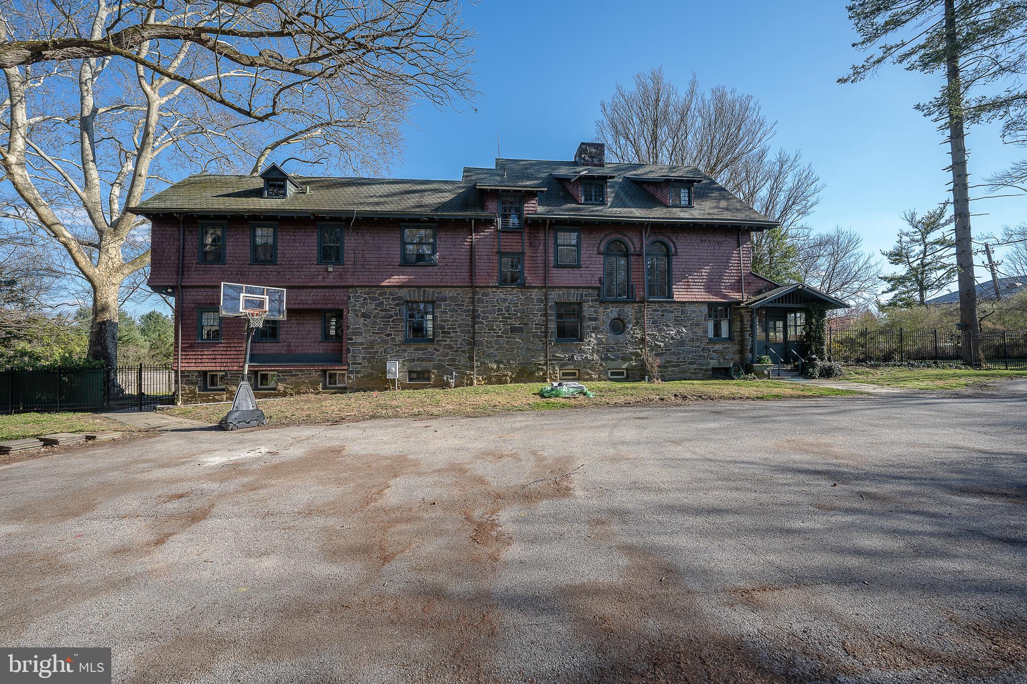 Situated on more than an acre of ground, this classic Main Line property features an impressive three-story stone home surrounded by stately trees, an expansive fenced yard, and a built in pool.  This solid home is ready for a new owner to bring it back to its full grandeur. Preserved original detail and elements throughout such as such as 5 panel sold wood interior doors and original butler pantry cabinetry offer timeless appeal and add to the character that will anchor the old with the new as updates are completed.  A glass vestibule on the right side leads to the charming Dutch Door providing access in characteristic old world style.  The welcoming Foyer with corner stone Fireplace and its wide main staircase that guides you to the second floor landing with windows along the front of the house allows an abundance of natural light into both the first and second floors.  The Foyer also houses an elevator which was one of the first residential elevators installed on the Main Line and adds architectural interest as well as function.  The spacious Living Room is on the right, straight ahead is a Powder Room on the left, the Butler Pantry which leads to the Kitchen and the Dining Room with French Doors opening to the yard.  Beyond the Kitchen is a Family Room with exposed stone wall and a mudroom with outside access thru an enclosed porch.  The informal area has two back staircases to the second floor, one from the Kitchen to the Main Second Floor and the other from the Family Room to a private ensuite Bedroom. The grand foyer staircase provides access to four nicely size Bedrooms as does the Kitchen Staircase. The Primary ensuite Bedroom is adjacent to a separate Bedroom through an arched Hallway, which currently houses a washer/dryer and built in cabinetry.  Expanding the Primary suite into this Bedroom still allows for 4 nicely sized Bedrooms on the second level.  At the top of the Main Stair Hall is an additional ensuite Bedroom with French doors that offer views overlooking the grounds and a fireplace. Down the hall is a Full Bath, an additional Bedroom as well as closed door access to stairs to the main level and third floor with high ceilings and very livable space. Three full Bedrooms, one with French doors that open to a covered balcony, a Bonus Room that functions well as a playroom, a finished storage area and a Full Bath complete this level.  The Basement has walk-out access to the left side of the house and daylight windows.  Newer Gas Heater and Gas Hot Water Heaters. 200 Amp Electrical Service.  This Prime location provides convenient access to all major roadways.  Walk to Villanova Regional Rail and Trolly Stations, Shopping and Restaurants, or a close drive or use the train to enjoy Dining and Shopping in nearby Wayne, Bryn Mawr and Ardmore as well as Conshohocken. Property is Class 2 on Lower Merion Historic Registry.