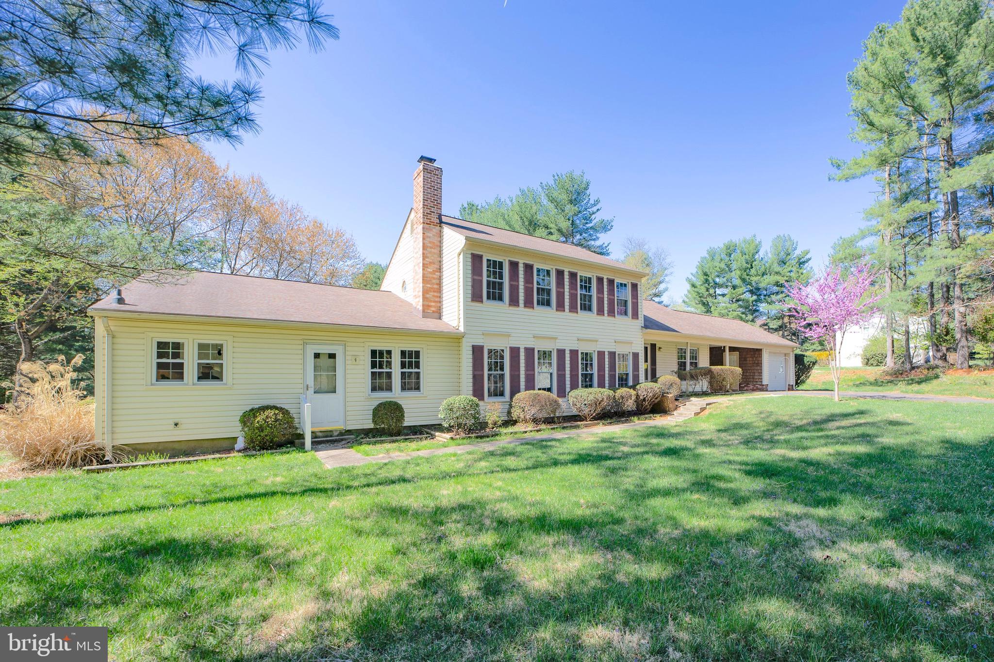 Unique opportunity! Beautiful home on lush, private 1.3 acre lot with attached apartment. This freshly painted property features new flooring throughout, a gracious foyer, eat-in kitchen, well appointed dining space and large living room, with access to the deck overlooking the rear yard and gardens. The oversized family room has a stunning brick fireplace and the additional den can be used as home office or guest suite. The upstairs boasts the primary bedroom with two closets and en-suite bathroom, as well as two additional bedrooms and a full hall bathroom.  The attached apartment is perfect for one level living, featuring an open kitchen, dining area, living room, sunroom, bedroom and bathroom. Covered parking, one car garage and a shed complete the property.