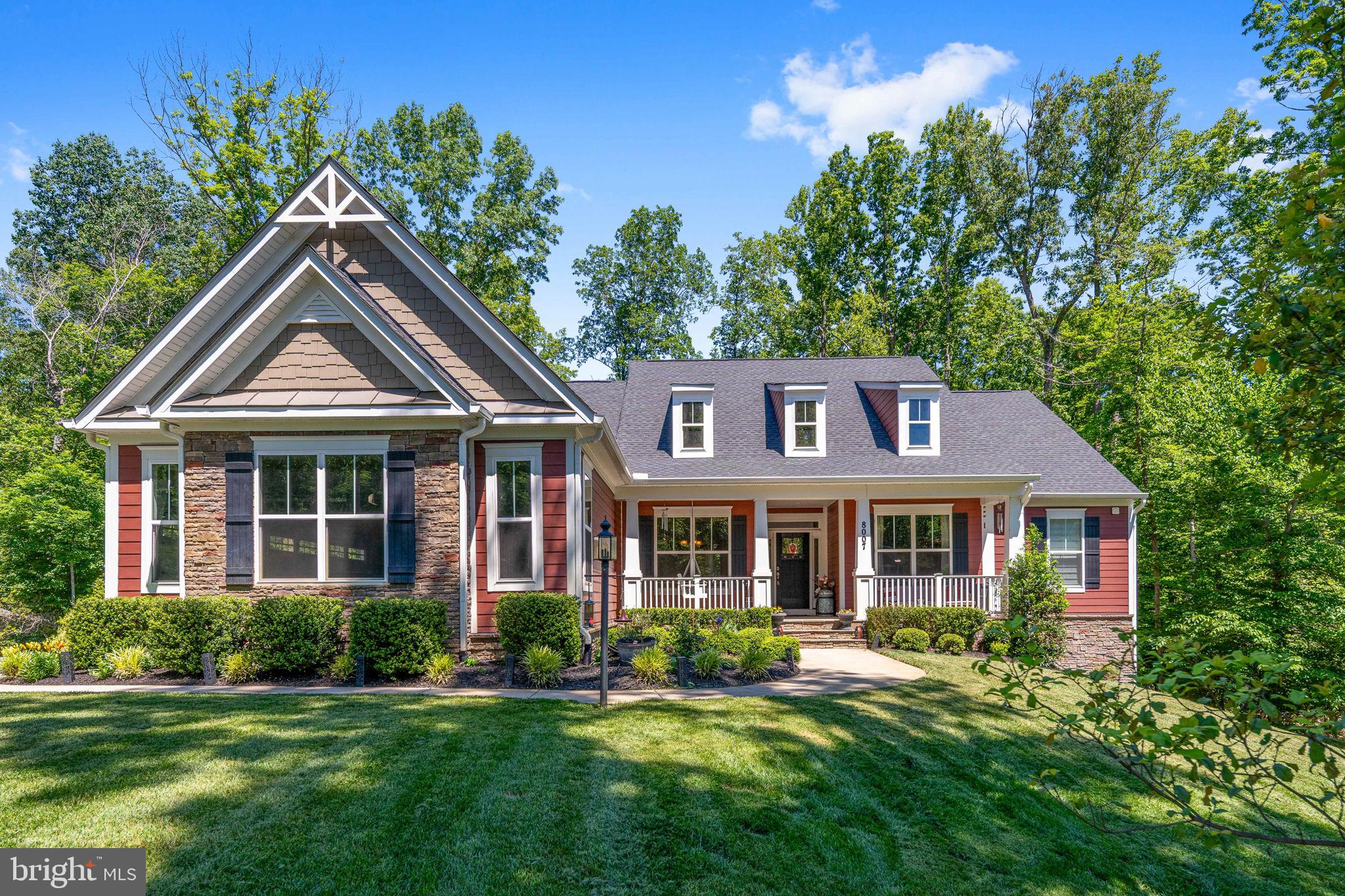 Welcome to 8007 Ashford Drive—where peaceful, wooded living meets thoughtful, award‑winning Atlantic Builders design (Bridgewater II). Tucked on a serene 2‑acre homesite, this beautifully maintained residence blends everyday functionality with true retreat. With 4 bedrooms plus a dedicated den and separate study, 3.5 baths, and multiple flexible living areas, it delivers the space, comfort, and charm buyers want—whether you’re hosting a gathering or enjoying a quiet morning coffee on the porch.

Discover the heart of the home: a showcase gourmet kitchen–family–sunroom trio that elevates daily living. The chef‑inspired kitchen centers on an extended grand island—ideal for meal prep, homework, holiday spreads, and casual dining—backed by abundant cabinetry and generous counters. It flows into the family room, where a striking stone fireplace with elevated hearth creates a warm focal point. High windows and vaulted ceilings bathe the main level in natural light, while the adjacent sunroom blurs the line between indoors and outdoors for reading, relaxing, or dining with treetop views. Open sightlines and the seamless layout make this hub perfect for entertaining yet intimate for everyday life.

A dedicated main‑level study offers an ideal work‑from‑home retreat or homework lounge. The welcoming front porch extends living out for greeting neighbors, unwinding at day’s end, or listening to rain in the trees. Wooded views add privacy and a calming rhythm to daily routines.

Convenience defines the floorplan. The main level hosts the primary suite for easy, single‑level living, complemented by two additional bedrooms nearby. A dedicated laundry room with full‑size washer and dryer keeps chores simple and out of sight. Wide transitions and practical circulation make the home feel both spacious and efficient, with storage thoughtfully integrated.

Downstairs, a largely finished walkout basement adds incredible versatility. A full kitchen rough‑in invites a future second kitchen or bar—ideal for extended‑stay guests, multigenerational living, or game‑day entertaining. This level includes a fourth bedroom paired with its own full‑size washer and dryer, plus an additional office/den for hobbies, exercise, or quiet work. A large, sectioned entertainment/movie room sets the stage for film nights, gaming, or a playroom, with room to zone for media, crafts, fitness, or music. Natural light from the walkout and direct outdoor access keep this level bright and connected.

With 3.5 baths, generous living spaces, and full‑size washers and dryers on each level, the home is designed for real‑world practicality without sacrificing style. The two‑acre lot offers room to roam, garden, or simply enjoy the seasons—dappled summer shade, brilliant fall color, and peaceful winter vistas. Mature trees enhance privacy while allowing soft daylight indoors. Everyday comforts pair with thoughtful details: the elevated hearth for easy fireside seating, the sunroom that captures morning light, and the extended island that naturally becomes the gathering place.

Set within Fredericksburg, the location balances quiet, wooded living with daily convenience. Enjoy quick access to historic downtown dining, boutiques, and riverfront parks, plus festivals and farmers markets. Major commuter routes and VRE stations connect to Northern VA, D.C., and Richmond while nearby shopping keep errands simple. Outdoor lovers have trails, the Rappahannock River, and regional parks close by; history buffs can explore renowned battlefields just minutes away. Top‑rated healthcare, respected schools, and a thriving small‑business scene round out a lifestyle that’s practical and connected.

Experience the serenity and flexibility of 8007 Ashford Dr - a rare blend of space, function, and a tranquil wooded setting!