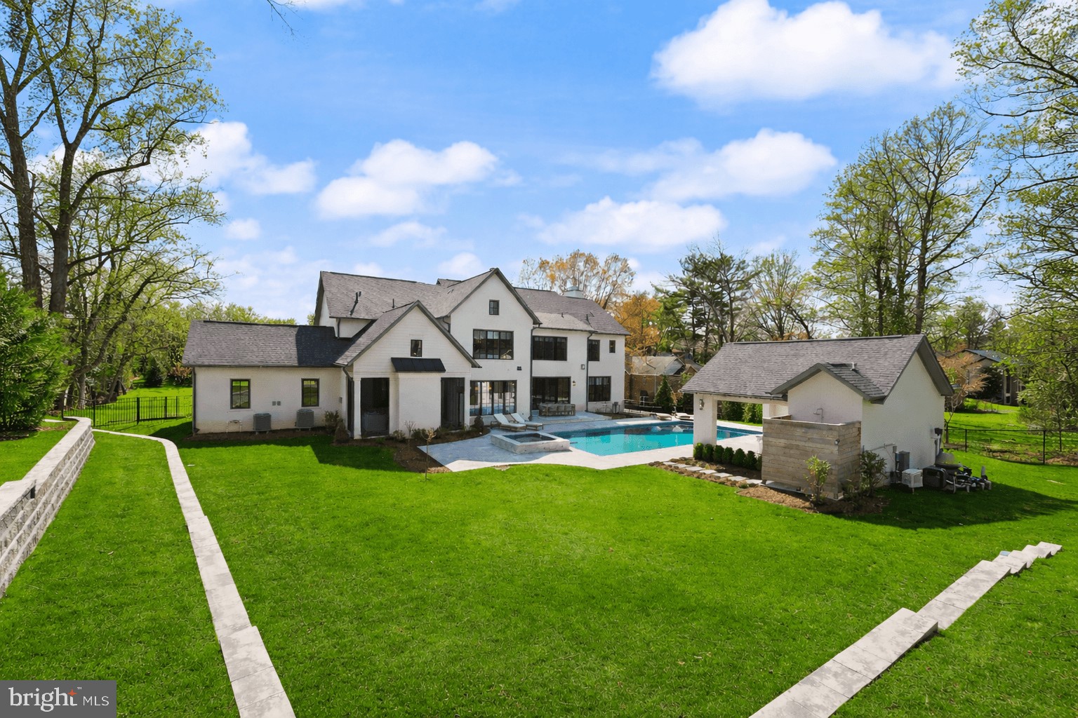 Welcome to 8230 Weller Avenue—a one-of-a-kind estate set on a beautiful 1.42 acre lot at the end of a quiet cul-de-sac in McLean’s coveted Dogwoods at Woodhaven. This  private, no-through neighborhood is surrounded by over 20 acres of shared parkland, including open fields and a scenic community pond.

The approximately 8,200 square foot home was originally built by Cherry Hill Custom Homes in 2024, the residence has been transformed by acclaimed design firm Georgia & Hunt into a bespoke masterpiece that blends coastal ease with classic Virginia architecture. Every space has been thoughtfully designed with layered textures, trim, color, and pattern, creating depth and character throughout.

Spanning approximately 8,200 square feet across three finished levels, the home offers 6 bedrooms, 6 full baths, 4 powder rooms, a three-car garage, and a circular driveway with central turf play lawn. The resort-style rear yard features a pool, spa, pool house, and fire feature, offering an exceptional indoor-outdoor living experience.

The main level boasts abundant natural light, 10-foot ceilings, and wide-plank white oak flooring. A striking three-story floating staircase and front-to-back sight lines create an open, airy, gallery-like atmosphere. The formal dining room features custom mural wallpaper and statement lighting, while the gourmet kitchen is appointed with top-of-the-line appliances, quartz countertops, custom cabinetry, and a fully outfitted prep pantry. A breakfast room and screened porch with vaulted ceilings, Turkish marble flooring, fireplace, and heaters enhance year-round entertaining.

The great room features a coffered ceiling, fireplace, built-ins, and sliding glass doors opening to the backyard. A mudroom with side service entry, family powder room, and dual garage access includes a secondary staircase to the upper-level lounge.

Upstairs, the owner’s suite is a serene retreat with a gas fireplace, dual walk-in closets, direct laundry access, and a spa-inspired bath with vaulted ceiling, heated floors, floating vanities, freestanding tub, and glass-enclosed shower. Three additional bedrooms each feature custom design details, while an upper-level lounge with full bath offers flexible living space.

The lower level includes a recreation room with fireplace, wet bar, and powder room, a fitness room, an additional bedroom with full bath, two flexible-use rooms, and a large storage area.

Outdoor living is exceptional, with a 20' x 40' heated pool with automatic cover and autofill, a separate spa, Turkish marble decking, and a pool house with covered pavilion, powder room with mini-split HVAC, outdoor shower, built-in storage, beverage refrigerator, and fire pit-centered lounge.

Located minutes from Tysons, McLean, and Spring Hill Recreation Center, and zoned for Spring Hill Elementary, Cooper Middle, and Langley High School, 8230 Weller Avenue offers a rare opportunity to own a fully realized luxury home where architecture, design, and lifestyle converge.