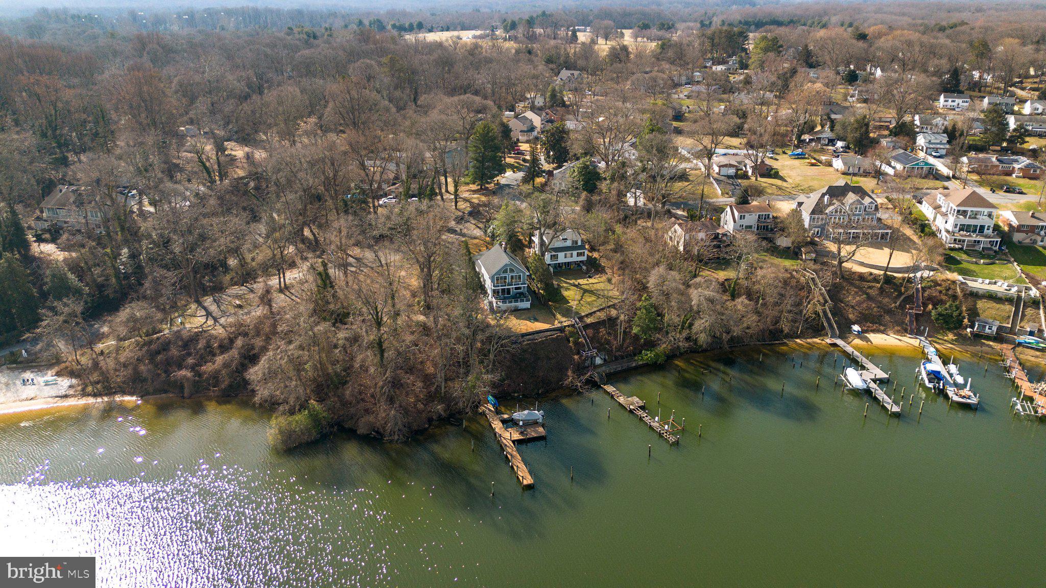 Exceptional waterfront with spectacular, huge views of the Severn River in sought after Arden on the Severn. Fabulous custom updates throughout this 4 bedroom, 3 full bathroom home. Private, multi-slip deep water pier, wonderful wrap around porch, and second story balcony maximize magnificent views capturing both sunrises and sunsets! The kitchen is a chef's dream with a Viking gas stove, stainless steel appliances, quartz counters, ship lap accents, a custom wet bar/coffee area & breakfast bar seating, all with expansive views to the Severn. Open concept living and dining rooms surrounded by walls of windows. This home makes entertaining a breeze with fantastic and inviting indoor and outdoor spaces. Custom built-ins, designer neutral paint, hardwood flooring, & updated lighting throughout- no detail was overlooked. Enjoy dual suites, one on each level. The main level suite offers a spacious bedroom set up with doors overlooking the water, a private full bathroom and a bonus sitting area. Two additional bedrooms and an updated full bathroom complete the main living level. Travel upstairs to a fully separate upper level suite. This is a true retreat- a brand new private bathroom with soaking tub, dual sided entry custom tiled shower, two vanities along with a separate water closet. Dual walk in closets, a bonus seating area overlooking the water plus a bonus room used as an office, or your home gym/yoga studio, with serene views of the Severn. Enjoy coffee or evening wine from the private balcony accessed via the upper level suite. Plenty of storage in the lower level or in the new storage shed.  Newer roof, Multi-zone HVAC. Voluntary HOA $35/yr. Arden on the Severn provides access to five community beaches, boat docks, play areas, pavilion, picnic areas and so much more! Schedule your private tour today