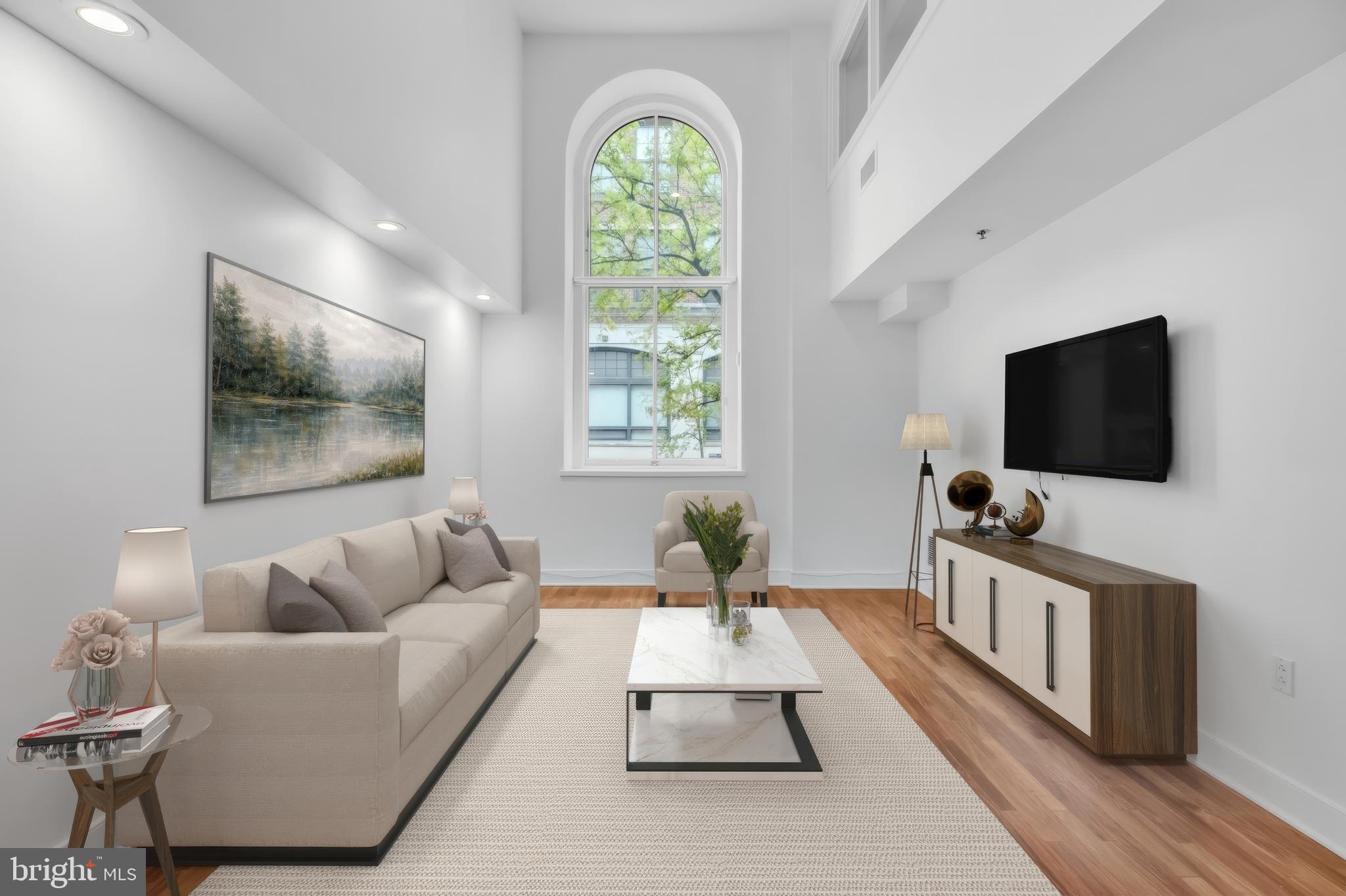 Presenting an exceptional opportunity to own a truly distinctive residence in the heart of Old City—a sprawling 2,119-square-foot, three-level condominium offering 2 bedrooms, a den, 2.5 bathrooms, deeded garage parking, and an unparalleled blend of architectural character, luxury finishes, and modern convenience. This pet-friendly home is thoughtfully designed to deliver both sophistication and comfort, creating an extraordinary living experience from the moment you arrive. A striking foyer welcomes you into the residence, immediately showcasing the home's impressive scale and elegant design. The main living level is highlighted by soaring ceilings and a dramatic 19-foot arched window that floods the space with natural light, creating an airy and inviting atmosphere. Rich cherry hardwood flooring, custom lighting, and refined architectural details enhance the grandeur of the open-concept living and dining areas. Practicality meets style with a generously sized front hall closet, an oversized laundry closet, and a beautifully appointed powder room featuring marble finishes and tile flooring. Designed for both everyday living and entertaining, the gourmet chef's kitchen is a standout feature. Appointed with granite countertops, custom all-wood cabinetry, and a premium suite of Viking stainless steel appliances—including a refrigerator, range, dishwasher, and microwave—the space offers abundant storage and exceptional functionality while maintaining timeless elegance. The main-level bedroom suite provides a private retreat for guests or family members, complete with a spacious closet, linen storage, and a luxurious en-suite bath. This spa-inspired bathroom features marble finishes, dual vanities, a soaking tub, separate stall shower, and tile flooring, creating a serene and sophisticated environment. Ascending to the upper level, the primary suite serves as a tranquil sanctuary. Framed by a beautiful arched window that fills the room with natural light, the suite offers a generous walk-in closet and a beautifully designed en-suite bath featuring a marble double vanity, tile flooring, and a tub/shower combination. The lower level adds remarkable versatility to the home, offering a substantial bonus living area with recently installed hardwood flooring. Ideal as a home office, media room, family room, fitness space, or guest retreat, this flexible level adapts effortlessly to a variety of lifestyles and needs. Additional highlights include deeded garage parking with keyed entry and the potential to accommodate electric vehicle charging, elevator and stair access, and a large private storage unit. With only sixteen residences in the building, owners enjoy an intimate, boutique-style atmosphere and a genuine sense of community rarely found in city living. Ideally situated in one of Philadelphia's most desirable neighborhoods, this residence places you steps from Penn's Landing Dog Park, Riverwards Produce, Radicchio Italian Restaurant, Café Ole, and the vibrant Delaware River waterfront. Enjoy easy access to Spruce Street Harbor Park, historic attractions, renowned dining, shopping, and entertainment, while benefiting from a convenient commute to Jefferson Health, the University of Pennsylvania, Cooper University Health Care, and Temple University Hospital. Combining exceptional square footage, architectural distinction, luxury finishes, deeded garage parking, and an unbeatable Old City location, this one-of-a-kind condominium offers an extraordinary opportunity to experience the very best of urban living.