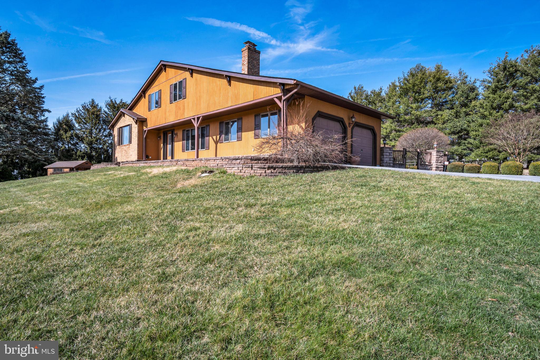 Welcome to your own private paradise on 5 acres featuring expansive, light-filled custom built Swiss chalet home, impressive backyard  for entertaining and plenty of manicured outdoor space, surrounded by scenic rural countryside with breathtaking sunsets! This one of a kind 3-4 Bed, 4 full Bath beauty has been meticulously crafted and maintained, offering an open, airy layout with Brazilian Cherry hardwood and custom tile floors, walls of windows, 4 fireplaces and a gorgeous Gunite in-ground pool framed by multiple patios, and artfully designed landscaping with colorful blooms, dramatic up-lighting, split rail fencing surrounded by a border of mature trees for total privacy. The sun-kissed Foyer reveals an elegant formal Living Room with field stone fireplace to the right, and an elevated formal Dining Room to the left which overlooks an open Family Room with wood stove and vaulted ceilings. The bountiful gourmet Kitchen is conveniently accessible from the Family room, and boasts custom hardwood and glass front cabinetry, matching range hood, granite counters, island with prep sink, premium stainless steel appliances and a relaxing Morning Room with custom tile hearth and perfect views of the pool and patios. The spacious laundry/mud room has outside entrance, full bath, tons of storage and built-ins ideally situated to freshen up after a swim. Upstairs, a decadent Primary suite composed of 2 large rooms, vaulted ceilings, private balcony overlooking the pool and massive spa bath with glass and tile shower, Jacuzzi tub, is sure to dazzle. The finished lower level with Rec Room, fireplace, bedroom, full bath and private entrance is ideal for in-law, teen or guest suite. Many comforts and luxuries are supplemented by practical amenities such as water purification system, handy potting shed, large shed with overhead door for mowers and equipment, oversized 2-car garage with brand new textured epoxy floor, and paved drive with large parking pad for additional vehicles. Peaceful setting off the beaten path, yet minutes to MD Line and 83 for easy commute to York, Hanover, Baltimore or DC Metro is the icing on the cake! Just unpack and start living the charmed life!
