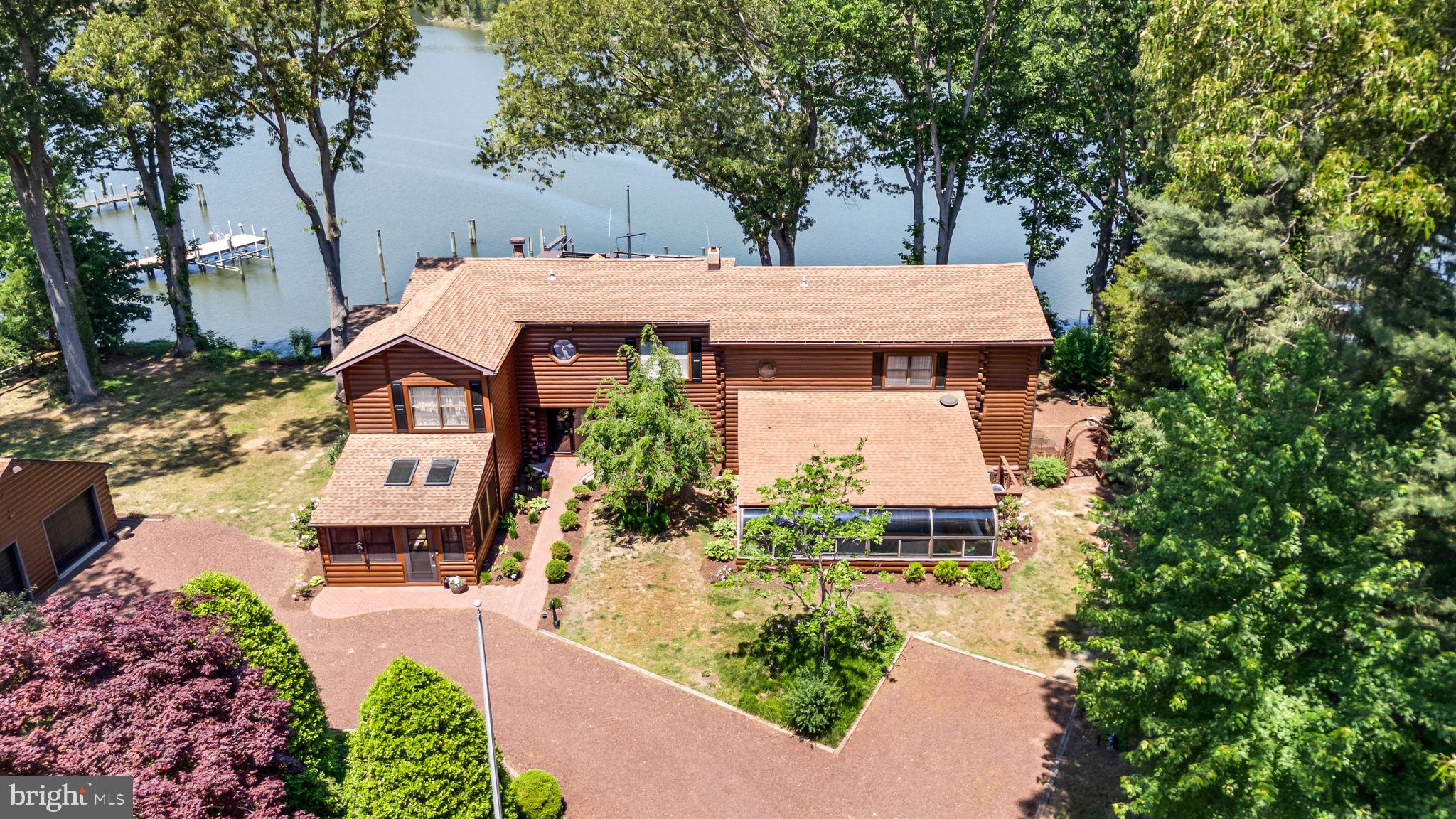 Sassafras Riverfront Retreat | Log cabin custom built home with Deep Water Pier, (seller had their 70 ft boat docked there for 10 years) with space for several boats to be docked as well. Indoor Pool looking to the outdoors with a glass enclosure and loads of space to entertain! There are 2 separate upper-level quarters, one for guests which includes a family room, sitting room and full bath. So much potential to utilize at least 2 of the rooms for bedrooms.  The primary suite on the other side of the home includes 2 walk-in closets, a dressing room. full bath with soaking tub, an office space and a sitting area with waterfront views.
Set on the tranquil shores of the Sassafras River, this striking log cabin residence blends timeless craftsmanship with resort-style amenities—perfect for effortless entertaining and relaxed waterfront living. The great room includes soaring beams, walls of glass, and panoramic river views
Deep water frontage with private pier, 3,000 lb. boat lift and ideal for larger boats as well, crabbing, fishing, and sunset cruising.
Year‑round indoor pool pavilion with lounge seating, beverage bar, and easy walk-out.
Chef’s kitchen featuring premium appliances, expansive island, and seamless flow to dining and outdoor spaces. Multiple decks and patios for al fresco dining, plus level lawn to the water’s edge. There is even a small kitchenette in the garage for those hardcore entertainers! A full house generator is also present and 3 HVAC units to cool the home.
This home would make an amazing Air B and B! 
There is an additional cabin with sleeping bunks and amenities for those overnight guests that never want to leave. Please click on the walkthrough tour and floor plans are also available.