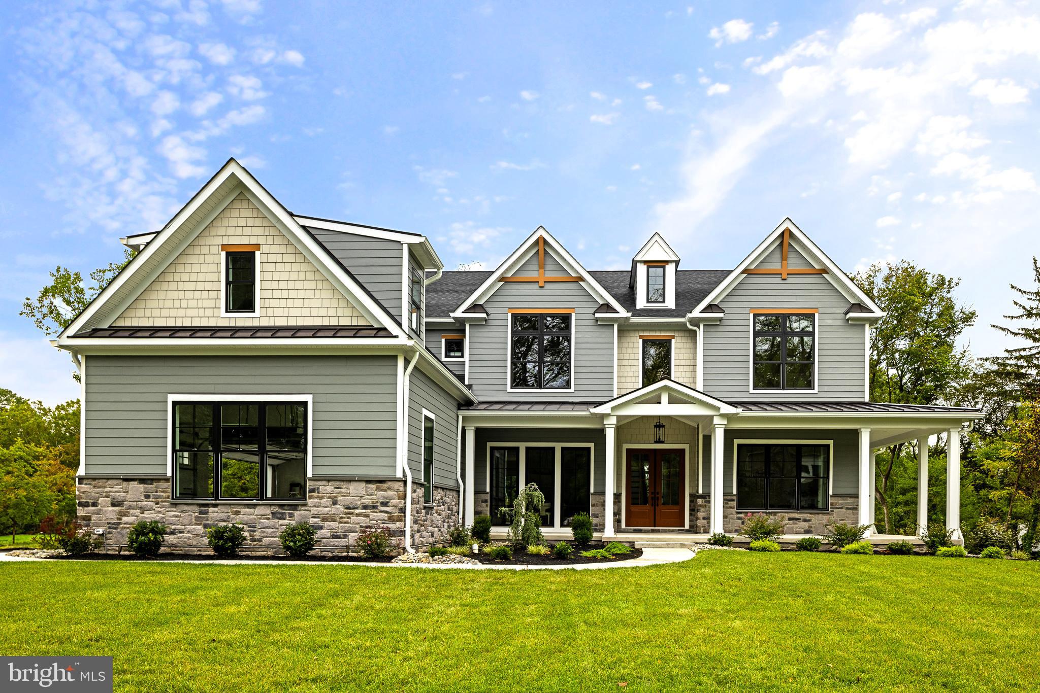 The Gwynedd Reserve is an intimate, boutique enclave of just five bespoke semi-custom residences, gracefully situated on a tranquil cul-de-sac in coveted Lower Gwynedd Township. These distinguished modern farmhouse-style residences offer a refined architectural sensibility, thoughtfully juxtaposed against the bucolic charm of their pastoral surroundings. A collaboration between the esteemed Mark Salamone Homes and Design Pro Development, this exclusive collection embodies a rare synthesis of craftsmanship, setting, and sophistication. Not merely a model home—but the pinnacle of design and craftsmanship. Welcome to 774 Johns Lane, an extraordinary new construction residence nestled at the heart of The Gwynedd Reserve. From the moment you arrive, lush landscaping and impeccable curb appeal set the tone for what lies within. Step inside to a soaring two-story foyer adorned with intricate trim work, immediately showcasing the home’s artisanal quality. To your right, through glass French doors, sits a private study—perfect for work or quiet retreat. To your left, a formal dining room is anchored by floor-to-ceiling windows, bathing the space in natural light and sophistication. At the heart of the home lies the breathtaking great room, with character-grade white oak hardwood floors and a dramatic floor-to-ceiling El Dorado Casa Blanca stone fireplace. Expansive windows invite in serene views, blending indoor and outdoor living. The adjacent breakfast area and kitchen redefine modern culinary excellence. A grand island sits beneath designer lighting, flanked by two-tone cabinetry, natural quartzite countertops, and artisan subway tile backsplash. Top-tier appliances include a 48” Wolf range with infrared griddle and Sub-Zero refrigerator. Just beyond, you’ll discover the pièce de résistance for any serious entertainer: a full scullery, finished in a midnight green palette with under cabinet lighting and featuring a second suite of appliances. Tucked just beyond the kitchen lies a well-appointed mudroom, thoughtfully designed with custom built-ins for both function and style. Completing the main level is a spacious guest suite, featuring its own beautifully finished private bath—an ideal retreat for visitors. On the second level, pause to admire the sweeping overlook of the great room. The right wing hosts two bedrooms, including a front-facing suite with cathedral ceiling and exposed wood beam, joined by a beautifully appointed Jack-and-Jill bathroom with a double vanity and tub-shower combo. A princess suite offers another vaulted ceiling with beam detail and a serene en-suite bath. Across the hall, the laundry room is reimagined with ceramic tile floors, custom built-ins, and a quartz countertop folding station. The lavish primary suite is a true sanctuary. Vaulted ceilings, designer fixtures, and shiplap accents elevate the space. The primary bath boasts dual vanities and an extraordinary floor-to-ceiling tiled wet room featuring a freestanding tub, rain and wall-mounted showers, a built-in bench, and architectural niches. A massive walk-in closet with custom storage completes the suite. The fully finished walkout lower level offers unmatched versatility—ideal for a media room, lounge, or game space. A kitchenette/bar area ensures effortless entertaining. A sixth bedroom with private full bath showcases beautiful green-tiled shower accents, adding a distinctive touch. Outside, the home flows seamlessly into the expansive backyard, a perfect canvas for pool parties, outdoor events, or peaceful retreats. Nationally ranked Wissahickon School District. Located just minutes from Ambler’s vibrant dining scene and regional rail access to Center City, this home blends the best of suburban luxury and urban convenience. 774 Johns Lane is more than a home—it’s a masterwork of design, scale, and thoughtful living, offering an unparalleled lifestyle in one of Lower Gwynedd's most desirable settings.