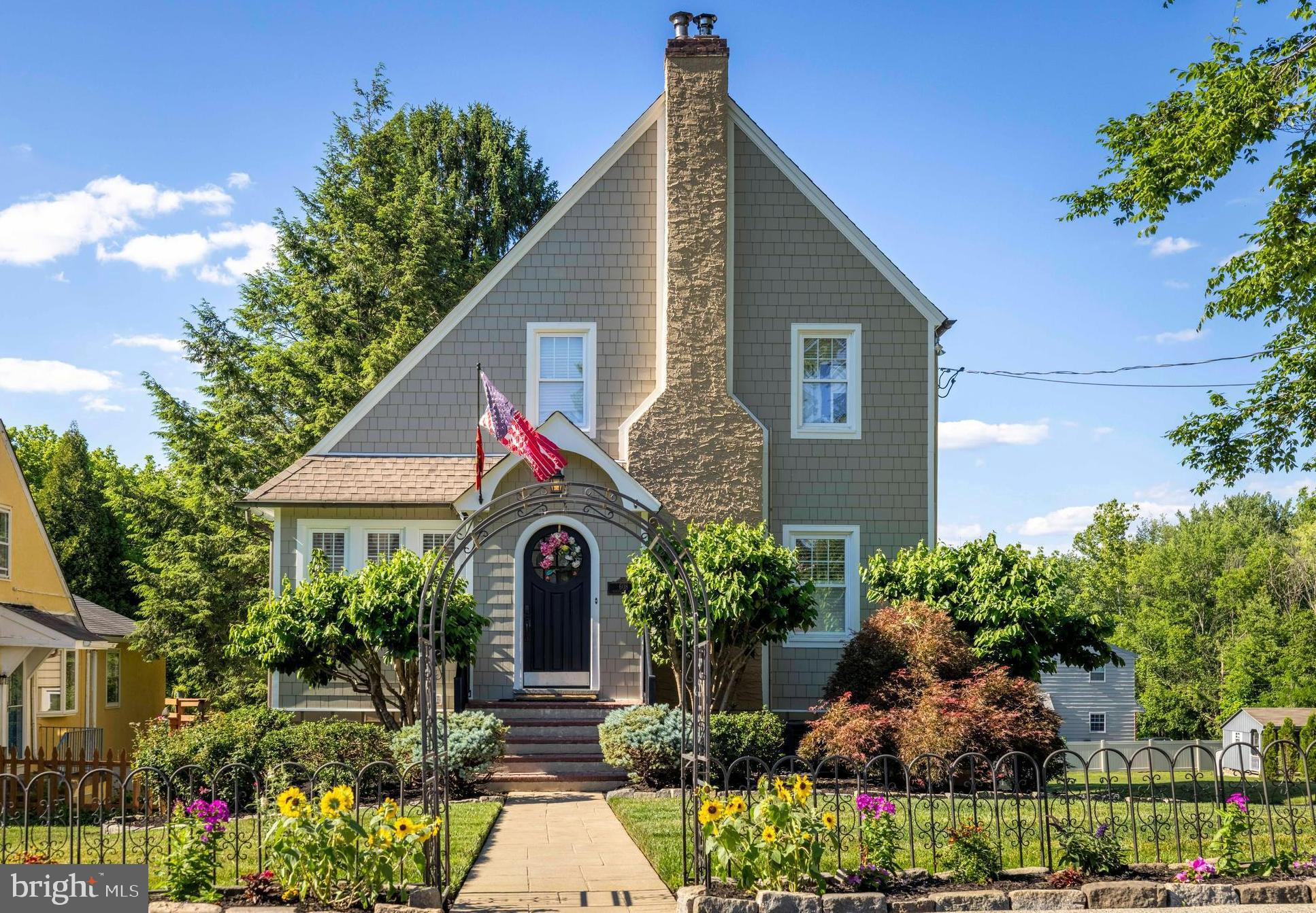 This custom-built, three-bedroom, two-full-bath home in sought-after Elliger Park in Fort Washington captivates from the very moment you arrive. A beautiful walkway and a distinctive rounded front door set a sophisticated tone, offering a preview of the unique architectural features found throughout. An enclosed foyer with a coat closet has beautiful hardwood flooring that extends through the majority of the home. The spacious living room features plantation shutters, custom millwork and a wood-burning fireplace with gorgeous woodwork and opens seamlessly to the formal dining room. This room is enhanced by custom raised-panel wood molding and serves as the perfect setting for family gatherings and holiday dinners. The huge chef's kitchen is a true showstopper, offering an abundance of cabinetry finished with crown molding,  alongside extensive counter space. This culinary space includes specialized appliance garages, a built-in cupboard with a counter and cabinets below, a large center island with seating, pendant lighting, a prep sink, an additional double sink, a tile backsplash, a six-burner stainless steel stove, a stainless steel refrigerator, and refined recessed lighting. A bright breakfast room is surrounded by a wall of windows and French doors that open to the rear deck, with steps leading down to the patio. A staircase with custom millwork leads to the second floor, where you will find three bedrooms, all with ample closet space, and a hall bath. The lower level features a spacious family room, a private office, a full bath with a stall shower, a laundry area with extra cabinetry and space for folding, and a utility room with extra storage. The lower level also provides easy access to the driveway and backyard, where you will find a huge stamped concrete patio, a wonderful entertaining area, and an absolutely gorgeous, level, fenced yard. For those who love to host, this is the ideal property, offering gathering space both indoors and out. This home has been lovingly maintained and offers a maintenance-free exterior. Ideally located just four minutes from the Fort Washington Train Station and only minutes from downtown Ambler, local restaurants, the Pennsylvania Turnpike, and the Fort Washington Swim and Tennis Club, this home is also within the highly regarded Fort Washington Elementary School district, offering an outstanding combination of character, space, and convenience.