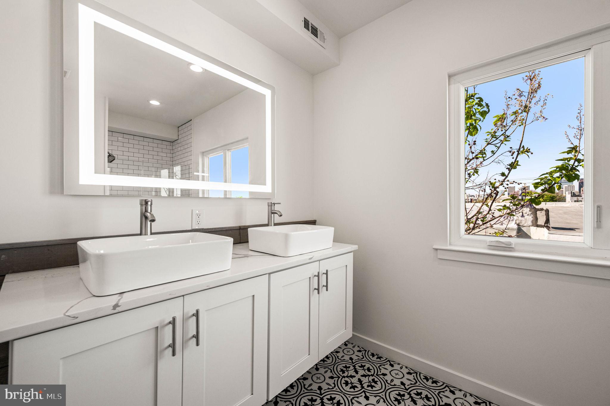 Welcome to 2045 Watkins Street, a beautifully crafted newer-construction townhome in Philadelphia’s vibrant Point Breeze neighborhood. Built in 2021 and offering approximately five years remaining on the tax abatement, this exceptional residence combines modern design, thoughtful upgrades, and everyday comfort.

Spanning three levels plus a fully finished basement, the home features 3 bedrooms, 2 full bathrooms, and 1 half bathroom. The open-concept main level is designed for both entertaining and daily living, showcasing wide-plank flooring, sleek modern railings, recessed lighting, and a stunning chef’s kitchen complete with stainless steel appliances. The kitchen flows seamlessly into the bright and inviting living area, where a built-in whole-house speaker system creates the perfect atmosphere for gatherings. A gas line concealed behind the living room wall provides an easy opportunity to add a fireplace and further enhance the space. Just beyond, a private concrete patio offers the ideal setting for outdoor dining, relaxing, or hosting guests.

The finished lower level expands the home’s living space with a versatile family room, media room, home office, or playroom, along with a laundry area, convenient half bathroom, and additional storage.

The second floor features two generously sized bedrooms with ample closet space and a well-appointed full bathroom. Occupying the entire third floor, the luxurious primary suite serves as a private retreat, offering expansive closets and a spa-inspired bathroom complete with double vanities and heated floors for year-round comfort.

A pilot house leads to the show-stopping roof deck, where sweeping views of the Center City skyline create the perfect backdrop for entertaining or unwinding. A convenient wet bar on the third floor adds another thoughtful touch for hosting family and friends.

Ideally located just south of Graduate Hospital and minutes from Rittenhouse Square, this home places you within easy reach of some of Philadelphia’s finest dining, shopping, parks, and entertainment.

Modern, stylish, and truly move-in ready, 2045 Watkins Street offers the best of contemporary city living.