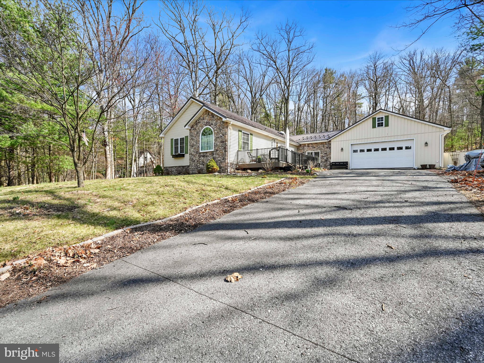 Welcome to this 3 bed, 2 bath beautiful ranch home in the Lake Wynonah gated community. Nestled on over half an acre of wooded serenity, this property offers the perfect blend of privacy and nature. The exterior boasts fantastic curb appeal with a spacious composite front deck, ideal for  a place to eat a meal and soak up some sun. A 24x32 pole building, currently used as an oversized two-car garage with a workshop, connects to the home via a breezeway. The paved and stone driveway provides ample parking for up to 10 vehicles. You'll also find a heated fish pond on the property, a back alcove which is a quiet place to spot hummingbirds and other wildlife as well as mature landscaping. Inside, the home opens to a large breezeway, perfect as a family room or flex space. From there, step into the inviting living room, featuring wall-to-wall carpet and plenty of space to entertain. Off the living room, a cozy nook with a pellet stove creates the perfect spot for a home office or library. The formal dining room is bright and welcoming, with French doors leading out to the deck. The updated galley kitchen boasts stainless steel appliances, granite countertops, and an eat-in area. The large master suite is a true retreat, featuring a relaxing sitting area, double closets, and a private en-suite bath with a double vanity and walk-in shower. On the opposite side of the home, you'll find two additional well-sized bedrooms and a second full bath. This charming home offers the perfect opportunity to enjoy peaceful living in Lake Wynonah, where residents have access to exclusive community amenities, recreational activities, and stunning natural surroundings. Don’t miss out—schedule your private showing today!  **HIGHEST AND BEST DEADLINE, SUNDAY 3/30 @ 9 PM**