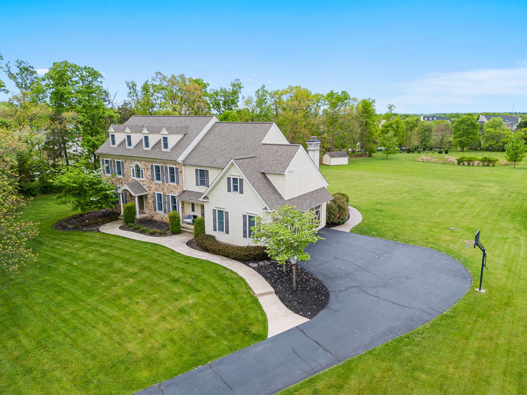 Welcome HOME to 912 Ashbourne Way located in Lower Salford and Souderton School District!  Offered at a new price and nestled in the highly sought-after Ashbourne Estates and walkable minutes to downtown Skippack, this stunning Colonial blends luxury, comfort, and everyday livability across more than 4,400 square feet of beautifully designed space. From the moment you step into the grand foyer, the home feels warm, welcoming, and made for both entertaining the most sophisticated events to everyday relaxing and enjoyment.  
The dining room is perfect for hosting gatherings, featuring a gorgeous tray ceiling and a full butler’s pantry with a wet bar and dishwasher for added convenience. The gourmet kitchen is truly the heart of the home, complete with high-end appliances, a commercial-grade side-by-side oven, a striking dark copper hood, and an abundance of granite countertop space. The oversized two-tier island makes entertaining effortless while still being ideal for everyday meals.
The open floor plan flows seamlessly into the spacious family room and expansive casual dining area designed to comfortably accomodate large gatherings and everyday living.  Surrounded with views of the open yard and in proximity to the kitchen so the chef never misses out on the conversation. The family room features brand-new carpet and a beautiful natural stone fireplace that creates the perfect cozy atmosphere. Looking for a quieter retreat? The formal living room offers oversized windows with private, peaceful wooded views. Just off the living room is a fifth bedroom with its own bath, making it an ideal setup for an in-law suite or private guest suite.  
Upstairs, you’ll find four more generously sized bedrooms, including an incredible primary suite designed to feel like a true retreat. Enjoy a large sitting room, two separate walk-in closets, and a luxurious primary bath featuring two private commodes, a dual entry shower, built-in vanity, and a soaking tub all surrounded by tons of natural light. Two additional bedrooms share a Jack and Jill bathroom while  overlooking the expansive backyard.  The 4th bedroom is such a unique delight boasting a hand crafted coastal mural in it's generous space while also containing its own private full bath.
Need even more room? The finished bonus room over the garage offers endless possibilities and even has room to add another full bathroom for an additional en suite. The sizeable upstairs laundry room adds convenience with extra storage and countertop space. A rear staircase leads down to the mudroom, complete with built-ins, two closets, and a second powder room with easy access to the garage, kitchen or the front of the home. 
The unfinished basement offers an incredible amount of storage and plenty of flexibility for a future gym, hobby room, or finished living space customized to your prefrences. 
Outside, the 1.84-acre lot provides a private, serene setting with a flat backyard perfect for entertaining, play, or simply relaxing. Enjoy evenings on the expansive paver patio or unwind in the hot tub while taking in the peaceful backyard oasis. Utilize the pole barn shed for the exterior maintenence items and leave the 3 car garage for parking your vehicles!  The long driveway provides ample parking and a great space for outdoor basketball! No need to worry about big ticket items.  This home has had a new roof, new garage doors, new grinder pump and a new water heater all in the last few years.  912 Ashbourne truly offers the perfect blend of luxury and comfort, with thoughtful details and versatile spaces throughout. Schedule your private showing today and make it your new home!!