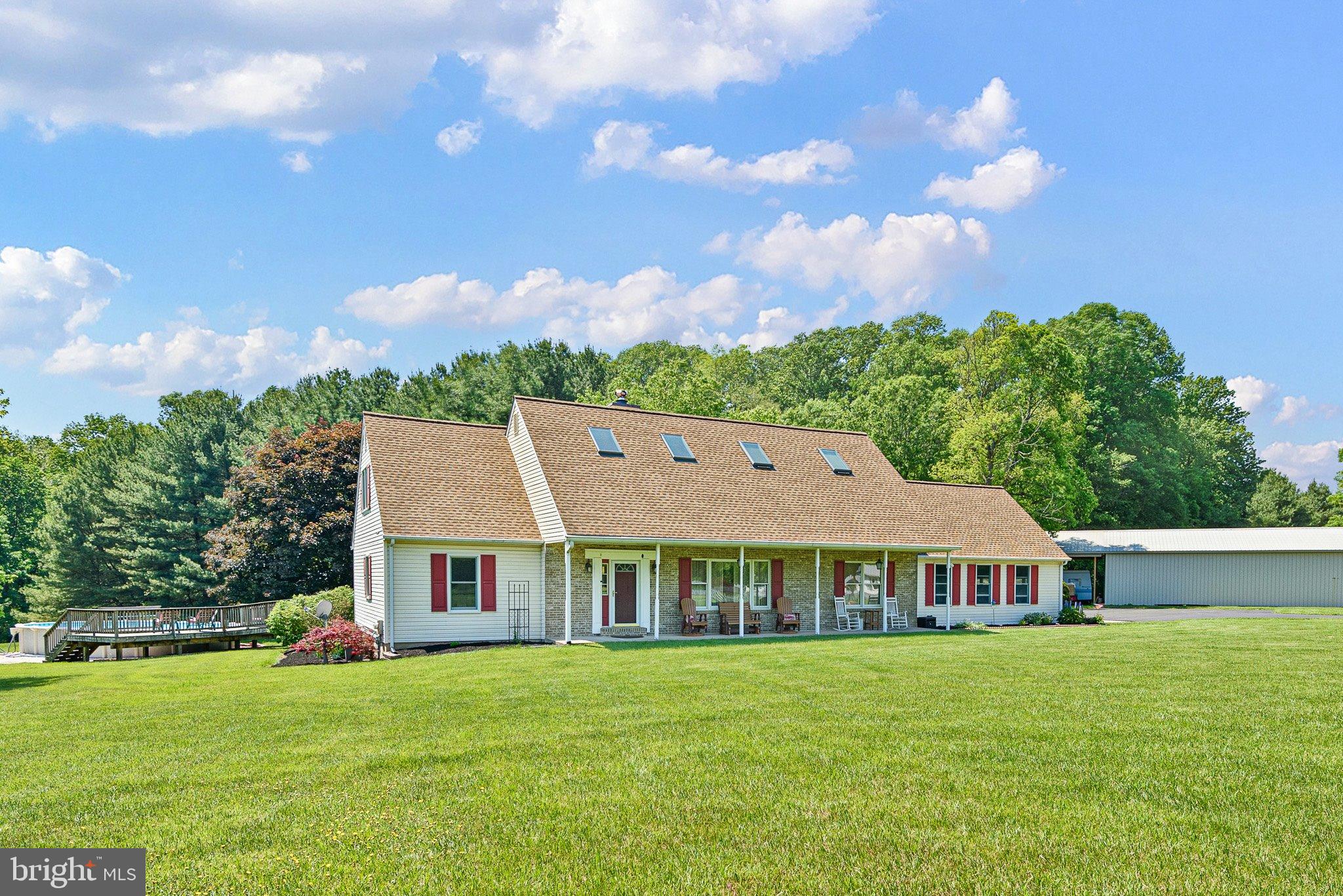 Welcome to 135 Blacksnake Rd — a lovingly and meticulously maintained 5-bedroom, 3 full and 2 half bath home offering over 4,000 square feet of living space; nestled down a long driveway on just over 4 peaceful acres in Fair Hill, MD! From the moment you walk through the front door, you are greeted by cathedral ceilings with exposed wood beams, hardwood floors, and a double-sided wood-burning fireplace that can be enjoyed from the sunken living room as well as the cozy den. 
 
Designed with both comfort and functionality in mind, this spacious home features TWO owners’ suites, including one conveniently located on the main level. The main-level primary suite offers a full bath, walk in closet, and access to the back deck and above ground pool through sliding glass doors! Continuing through the main level, the country kitchen is both charming and practical, featuring stainless steel appliances, abundant cabinet space, and plenty of room to gather! Just off the kitchen, you’ll find a separate eat-in dining room, with dining furniture included in the sale, creating a move-in ready space perfect for hosting dinners and holidays. The den includes a half bath and direct access to the covered back deck, making it the perfect space for relaxing or entertaining guests year-round. The large mudroom provides access to the attached two-car garage as well as the backyard, and is equipped with main-level laundry for everyday convenience.  
 
Moving upstairs, you’ll find four additional bedrooms, including a second owners’ suite with walk in closets and private balcony access overlooking the backyard. The en suite offers a soaking tub, double sinks, and a remote controlled skylight. There is an additional full bath on the upper level that is also equipped with a remote-controlled skylight, bringing in beautiful natural light with added convenience and modern functionality. Downstairs, the partially finished basement adds even more flexible living space and includes an additional half bath! The unfinished area provides tons of extra storage space. Major updates have already been completed, including a new roof and gutters with LeafFilter gutter guards and skylights all replaced in 2020, a new AC unit installed in 2023, new windows in 2022, newly paved and sealed driveway, and a tankless hot water heater added in 2024. If you’ve been searching for acreage, SPACE, charm, and country living, this exceptional property is one you won’t want to miss!