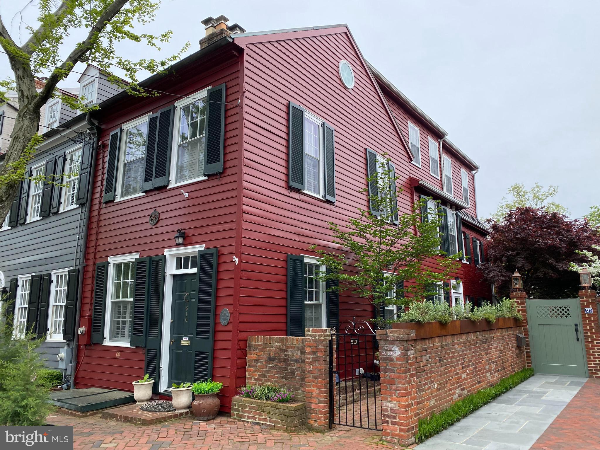 Located on one of the most picturesque streets in the heart of historic Old Town Alexandria, this charming 1826-built home seamlessly blends the elegance of the past with today’s modern amenities.  
As you enter the home, you're greeted by beautiful original hardwood floors that lead you into the colonial-style living and dining areas—perfect for intimate gatherings or quiet evenings around the hearth of the gas fireplace. The updated kitchen, combined with a cozy den with gas fireplace, is ideal for casual entertaining, with direct access to the tranquil, back garden, surrounded by brick walls with a brick patio that offers a peaceful escape right at your doorstep. Take your pick of two sets of stairs leading to the upper levels! 
On the second level, you’ll find three generously-sized bedrooms and two full baths, all updated for comfort and style. The front bedroom has built in shelves while the back bedroom enjoys its own private sitting porch—a serene spot to unwind. The other bedroom on this level is equally spacious, with plenty of room for family or guests.
The expansive primary suite, located on the 3rd floor, offers a private retreat with stunning views from a balcony that overlooks the historic rooftops and lush gardens surrounding the property. This room is filled with natural light and provides ample space for both relaxation and storage.
Plantation shutters provide privacy in LR, DR and front bedroom. Sunlight pours into the abundance of windows(24) on all 3 sides of this unique home. 
Don't miss the bonus space in the finished basement. Exposed brick and the painted coffered ceiling makes this space charming and practical. Perfect for a recreation room, workout room/gym. There is plenty of storage space with room to be creative.  
Don't miss out on the blend of historic character and contemporary updates in this rare Old Town gem.