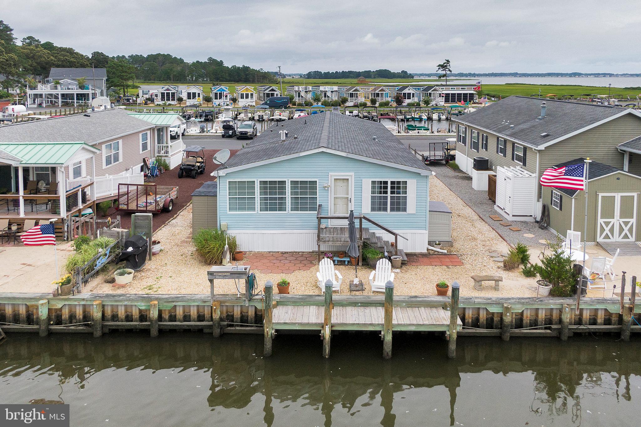 Canal front in West Bay! Park your boat in your private dock right in your back yard! Boaters paradise! This is not your typical manufactured home. This extra large 1,800 sq' home features 2 bedrooms, 2 full baths, dining room, living room, family room and bonus/office room. Rarely do you see a manufactured home boasting all four living areas. Relax in the front sunroom that's enhanced by the East Breeze self storing windows enabling year round pleasure. The entire property is landscaped with stone thus eliminating tedious grass cutting and offers plenty of parking for 8. West Bay is a "life style" community. Amenities include a general store, restaurant with rooftop deck, inground pool overlooking Rehoboth Bay, community center, kids playground, huge Gazebo overlooking Rehoboth Bay, fishing & crabbing pier, basketball court and let's not forget about the marina and boat launching facilities. Lots of community activities, live bands, holiday parades and the list goes on and on throughout the year. Wildlife abounds in the adjacent tidal marsh. Watch the ducks, geese, otters and countless bird varieties, all within sight of your own back yard. This home is impeccably clean so please take your shoes off when viewing. Make an appointment for your private showing of your new waterfront home!