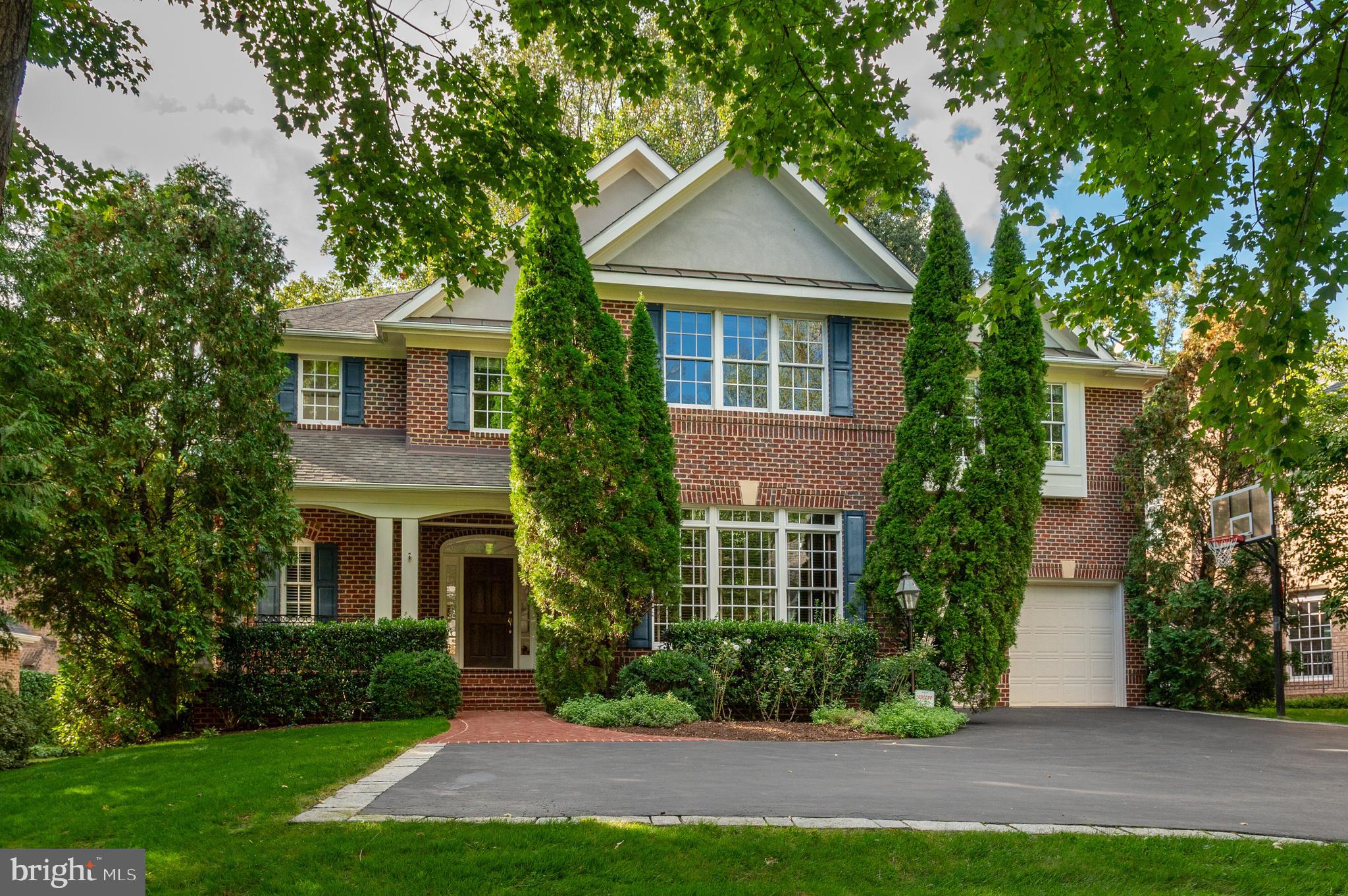 Set within one of Bethesda’s most coveted neighborhoods, this distinguished residence, offering nearly 6,500 square feet of beautifully finished space, gives the home an excellent flow for entertaining and everyday living. Designed for both intimate family moments and grand-scale entertaining, the home rests on a professionally landscaped .42-acre lot, where stone walls and lush plantings create a private sanctuary. A soaring two-story foyer, graced with gleaming hardwood floors and a sweeping curved staircase, introduces the main level. The formal living room, crowned with 19-foot ceilings and a striking oversized window, flows seamlessly into a refined formal dining room framed by bay windows and a charming window seat. The heart of the home, the expansive kitchen, is outfitted with custom wood cabinetry, a center island with seating, and a generous informal dining area that opens to the deck terrace and gardens. Adjoining this space, the family room offers built-ins, a stone hearth gas fireplace, and direct access outdoors. Completing the main level is a distinguished library, powder room, and oversized two-car garage.

Upstairs, four spacious bedrooms include an exceptional primary suite. Walls of windows overlook the verdant rear grounds, while tray ceilings, a serene sitting area, and a custom walk-in dressing room elevate the sense of luxury. The primary ensuite features dual vanities, a jetted soaking tub, and a glass-enclosed shower with dual showerheads. The fully finished lower level offers a recreation room, mirrored gym, home theatre with projection system and luxury seating, plus a guest suite with full bath—perfect for hosting extended family, an au pair, or overnight visitors. The rear exterior offers an expansive deck, yard space and play house. Beyond its interiors, this home’s prime Bethesda location places it within close proximity to Walt Whitman High School, the Capital Crescent Trail, and the boutiques and dining of downtown Bethesda, with easy access to the Beltway.