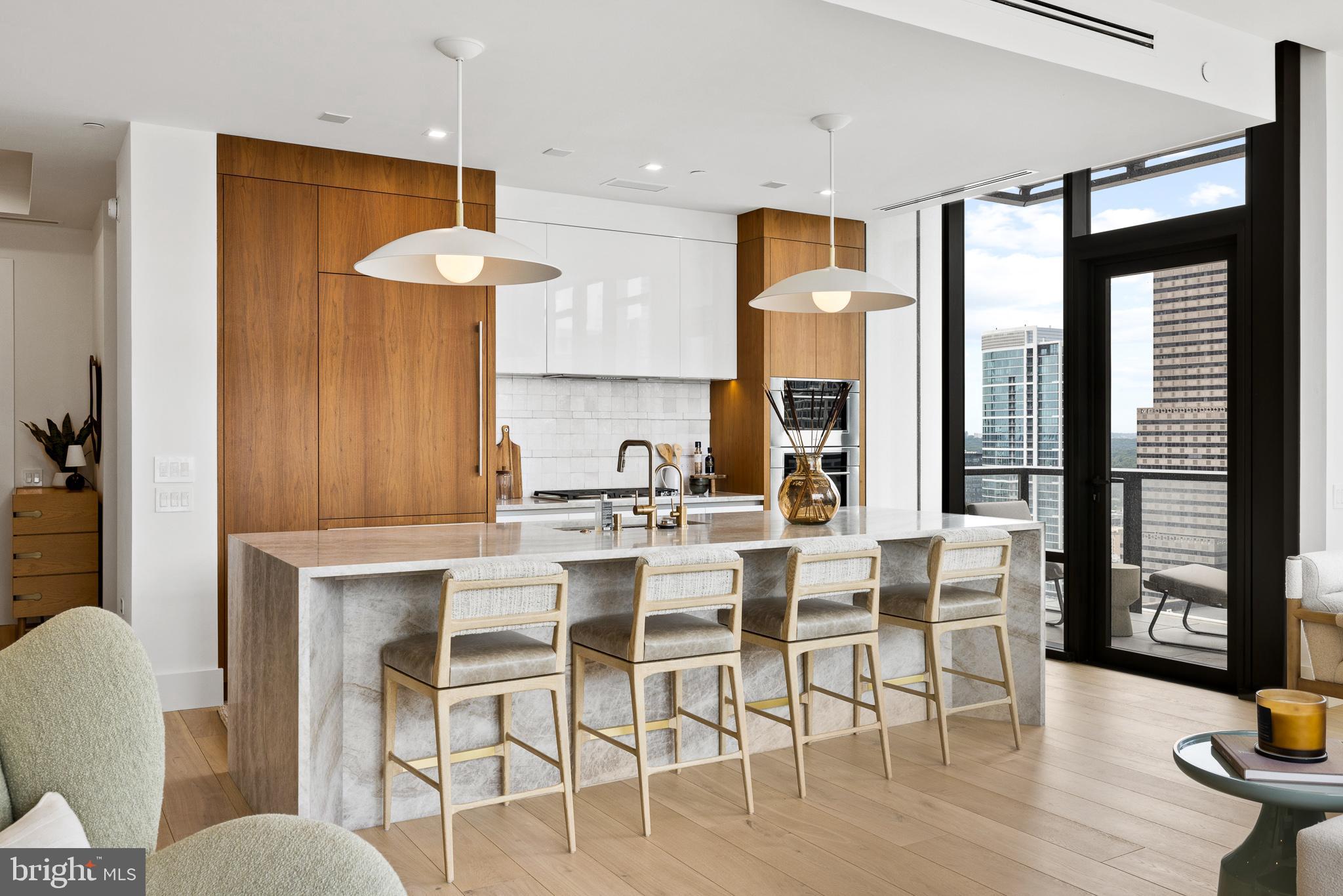 Welcome to Unit 2804 at The Laurel, an exquisitely upgraded 2-bedroom, 2.5-bathroom residence offering elevated living in one of Philadelphia’s most prestigious addresses overlooking Rittenhouse Square. This modern city home is a masterclass in sophisticated design, featuring high-end custom finishes, intelligent storage solutions, and refined architectural touches throughout. Upon entering, you are welcomed by wide, newly installed 11-foot Warren Christopher plank wood flooring that spans the living areas, creating a warm yet contemporary atmosphere. Anchoring the main living space is a custom-designed limestone fireplace, encased in white oak-stained wood with integrated LED-lit shelving and discreet hidden storage—perfectly blending function and style.
The gourmet kitchen is tailored for the modern chef, boasting a stunning quartzite slab with 22 thoughtfully positioned outlets, under-cabinet LED lighting, and a sleek Italian tile backsplash. The bar area and bathrooms have all been fitted with upgraded designer faucets, while the kitchen sink includes a premium Julian basin, upgraded garbage disposal, and a hot/cold filtered water system for added convenience. Adjacent to the kitchen, the laundry room has been thoughtfully transformed into a multifunctional space with built-in step stools, drying racks, upgraded washer and dryer, and dedicated electric access for charging your Dyson vacuum—an uncommon yet thoughtful feature in city living.
Both bedrooms offer generous proportions, enhanced by custom closet systems, recessed cam lighting, and electronic window shades for ultimate privacy and light control. The primary suite serves as a serene retreat, while the second bedroom is equally well-appointed. The half-bathroom stands out with an integrated sink, upgraded Morro fixtures, and custom lighting. Every detail throughout the home has been meticulously upgraded—from all new door hardware and custom light fixtures to repainted walls, added wallpaper accents, and upgraded baseboards for a cohesive and polished finish.
For peace of mind, the home is equipped with a built-in security camera, while smart lighting and shade systems contribute to the residence's modern appeal. This turnkey home is a rare blend of beauty and function, combining premium materials with bespoke design touches.  Sale includes two parking spaces and an assigned storage unit offering additional space for the owner. 
As a resident of The Laurel, you will enjoy access to an unparalleled suite of luxury amenities and full-service conveniences. Building amenities include an indoor and outdoor pool & hot tub, a stylish bar and lounge, 24-hour concierge, elevators, state-of-the-art fitness center, sauna, guest suites, golf simulator, meeting and party rooms, round-the-clock security, and even transportation services for added ease.