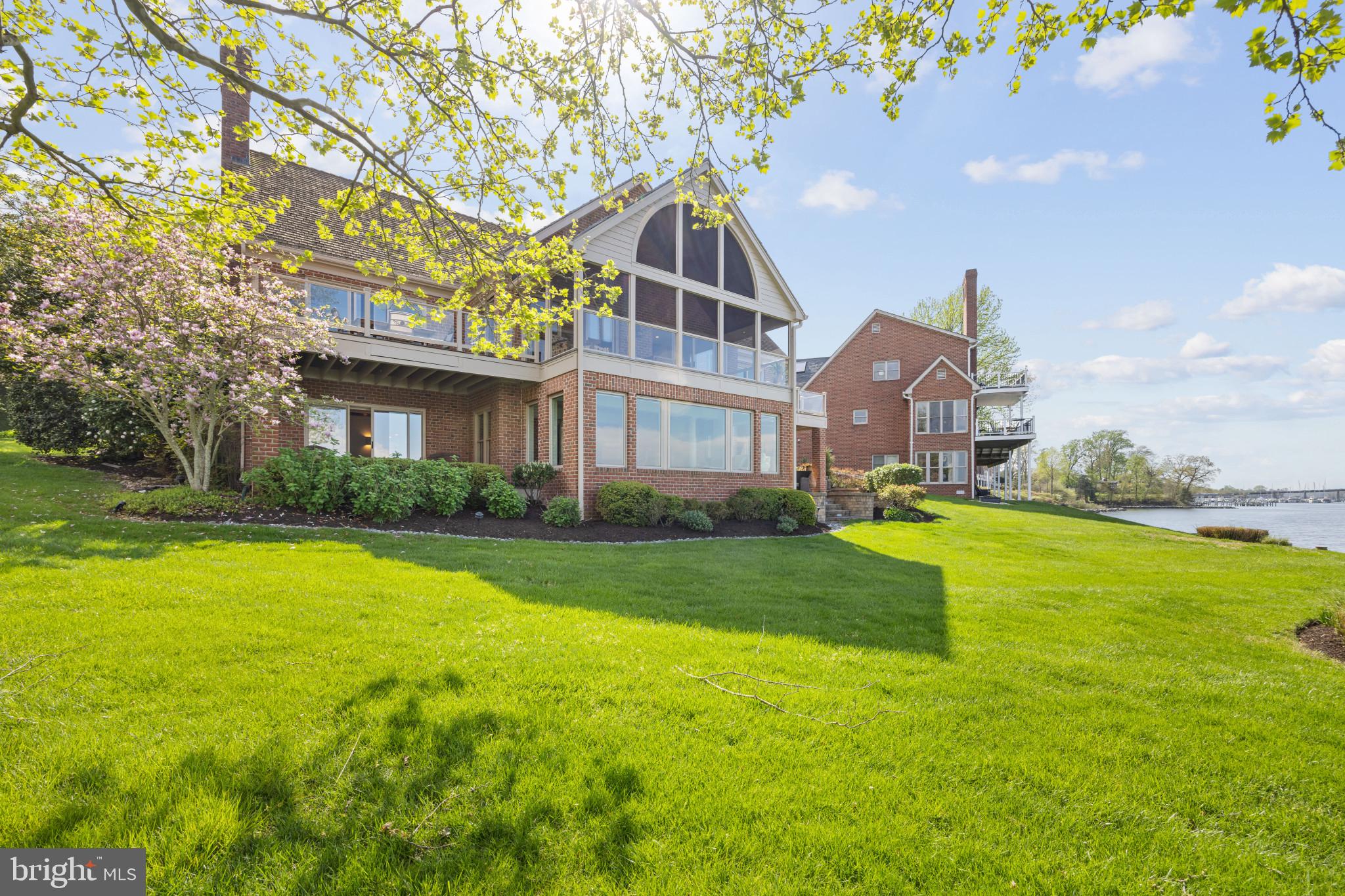 Sweeping water views and impeccable craftsmanship in this serene resort-style luxury waterfront community of South River Landing. Crafted with meticulous attention to detail, this custom all-brick home offers an open layout with the primary bedroom on the main level and a large grassy yard..

Upon entry, you're greeted by views of the water and a stunning wood-paneled, barrel ceiling with a stacked stone gas fireplace. A lovely screened porch and second grilling porch seamlessly blend indoor and outdoor living. The primary bedroom offers a private deck, spa-like bathroom, and generous walk-in closet, with laundry conveniently located on the main level along with a second bedroom.

Entertain with ease in all the open living spaces. The walkout lower level offers floor-to-ceiling windows with panoramic views of the waterfront. This space is flooded with natural light and includes a gas fireplace, second family room, gym, two additional bedrooms, or a large office, and a well-appointed bar area, perfect for hosting gatherings.

Outside, enjoy a waterfront yard, stone patio, and second deck that are ideal for al fresco dining or relaxing by the water's edge. South River Landing amenities include 24/7 security, landscaping services, a private waterfront pool, deep water marina, tennis courts, playground, private beach, and nature trails.

With exterior maintenance handled by the community association, this is a perfect retreat year-round. Boaters will appreciate the easy access to the Chesapeake Bay (without any bridges) while waterside restaurants are just minutes away. Life is truly better without the hassle of maintenance, especially in this waterfront lock-and-leave community! Close to Washington DC, Baltimore, and downtown Annapolis. Don't miss your chance to experience the luxury and convenience of South River Living!