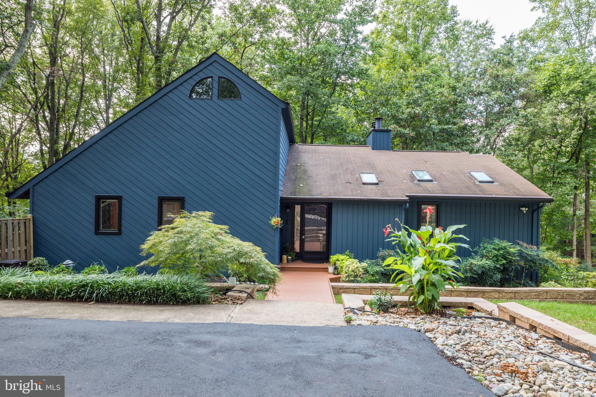 Stunning contemporary style single family home in tucked away off Oakton Rd on just over an acre of gorgeous land. Enjoy the great outdoors here with a grassy area, perfect for playing, and a spacious wrap around deck backing to the wooded landscape. Inside, the hardwood floors, neutral paint and countless upgrades make the perfect backdrop for your furnishings.  The main level features 3 spacious bedrooms and 2 full baths. A private loft on the upper level with a half bath can double as a rec room or guest suite. The lower level  features a gourmet kitchen, 2 story dining area and tons of natural sunlight from the floor to ceiling windows. Ample parking available with a detached 2 car garage, paved driveway, and easy access to get back out onto Oakton Rd. Enjoy, and welcome home!