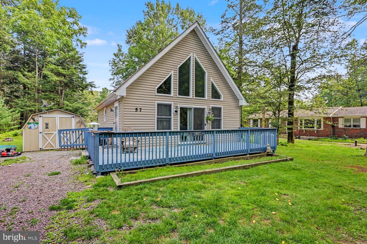Well-maintained 2 bedroom Pocono chalet nestled on nearly 1/3 acre in desirable Holiday Pocono is just minutes from 903, 940 , Lake Harmony, Jack Frost/Big Boulder, & Pocono Raceway. Easy access to Camelback, Camelbeach, Kalahari, White Water Rafting, Mt Airy Casino, and plenty of shopping at the Crossings Premium Outlets! The great room boasts cathedral vaulted ceilings, stunning wall of windows & sliders, gleaming Pergo flooring, and gas fireplace with stone surround! The bright kitchen features plenty of cabinetry, peninsula island, double sink, & new floors. The two first floor bedrooms have 6 paneled doors, wall-to-wall carpeting, neutral paint, large closets, & modern ceiling fans. The expansive loft is fully carpeted and can be used as a third bedroom! Award-winning Jim Thorpe School District! The community amenities include 2 pristine Placid & Holiday Lakes--one stocked for fishing and the other for swimming--plus a rifle range, clubhouse, pavilion, and other park amenities. Don't miss out on the opportunity to own this adorable retreat in the heart of the Pocono Mountains! This peaceful community does not allow STR's so you can bask in the serenity and calm year round! Don't forget the large shed for storage, as well as the lush backyard with firepit!